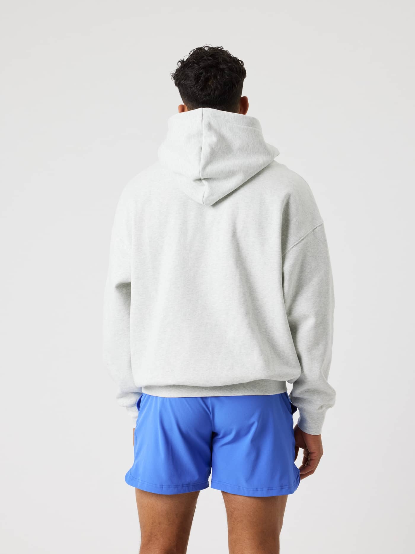Back view of a man wearing the Björn Borg Oversized Hoodie in Ultra Light Grey Melange (Grey) for style, fit and function. - Image 4
