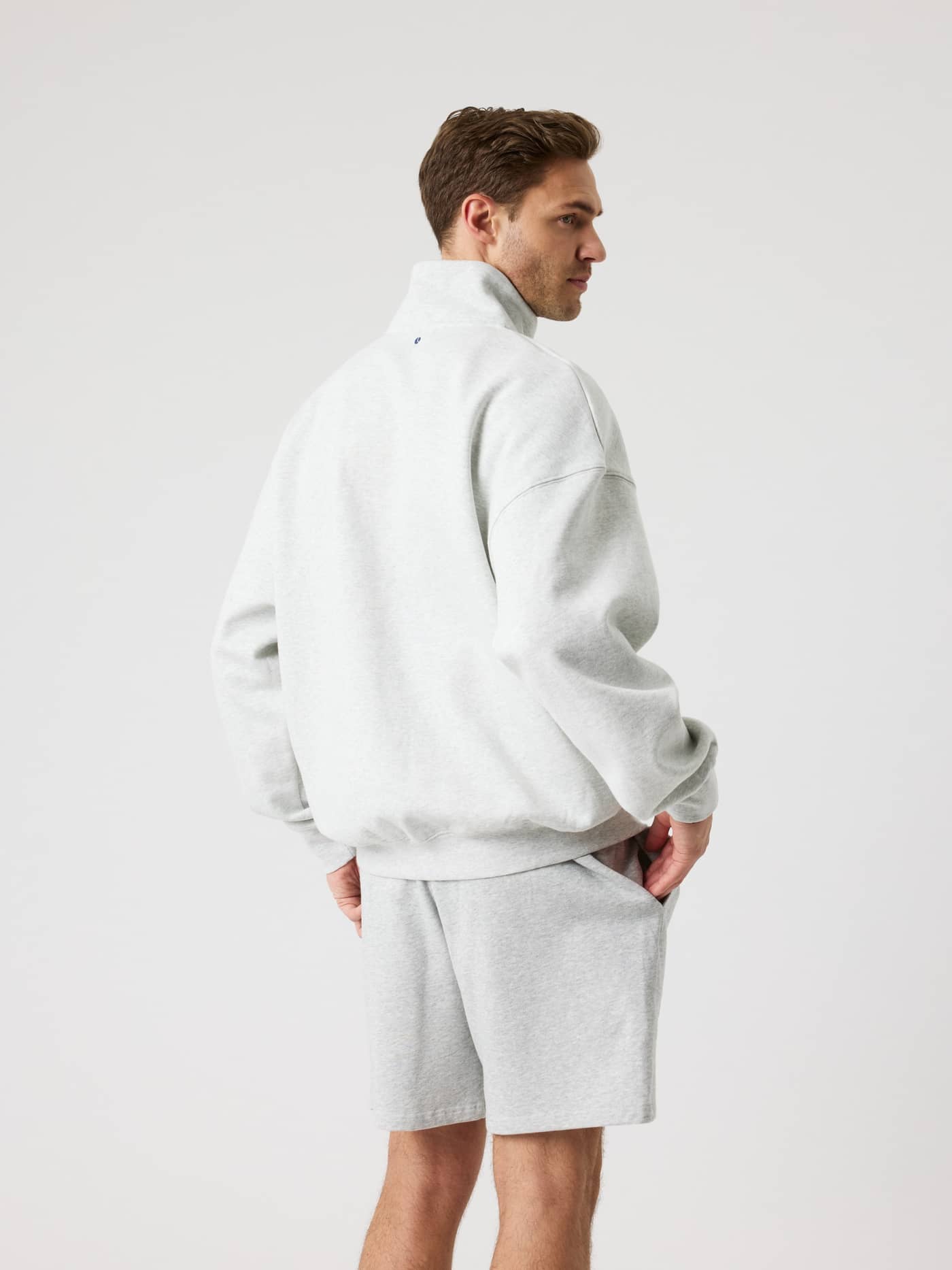 Rückansicht eines Mannes im Borg Oversized Half-Zip in Ultra Light Grey Melange (Grau) mit lässiger Tennis-Passform. - Image 3