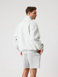 Rückansicht eines Mannes im Borg Oversized Half-Zip in Ultra Light Grey Melange (Grau) mit lässiger Tennis-Passform. - Image 3