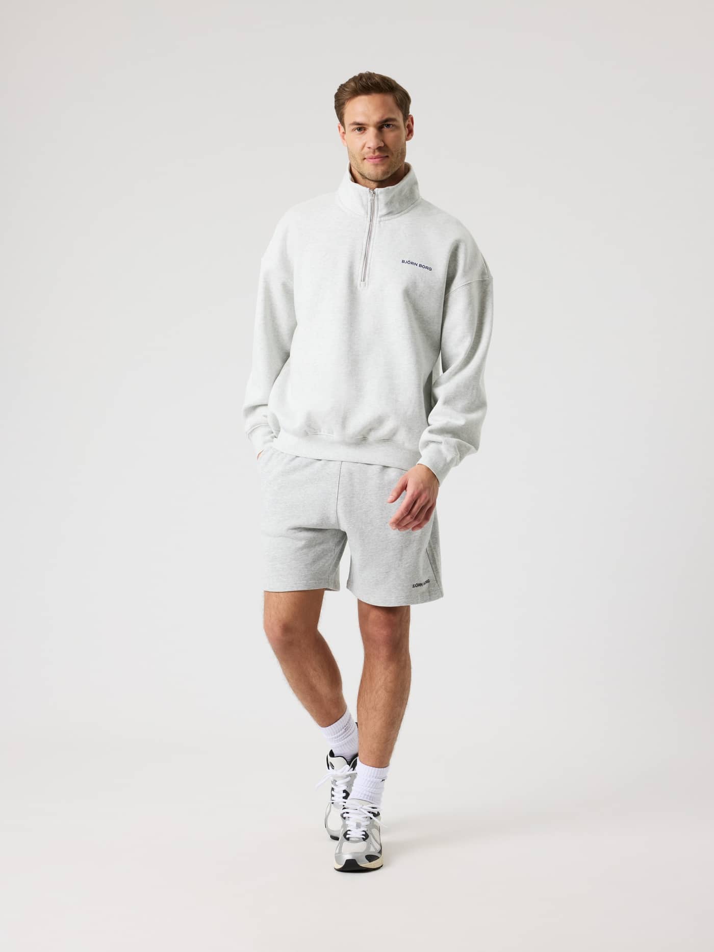 Vorderansicht eines Mannes im Borg Oversized Half-Zip in Ultra Light Grey Melange (Grau) für Training mit schwarzem Logo. - Image 4