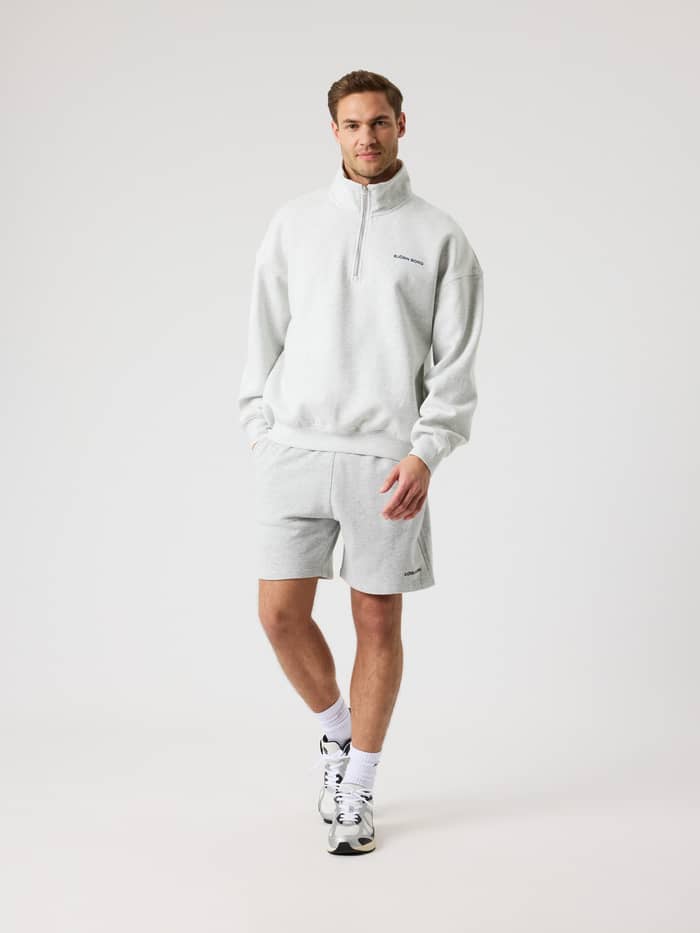 Vooraanzicht van een man in de katoenen Borg Oversized Half-Zip in Ultra Light Grey Melange (Grijs) voor training. - Image 4