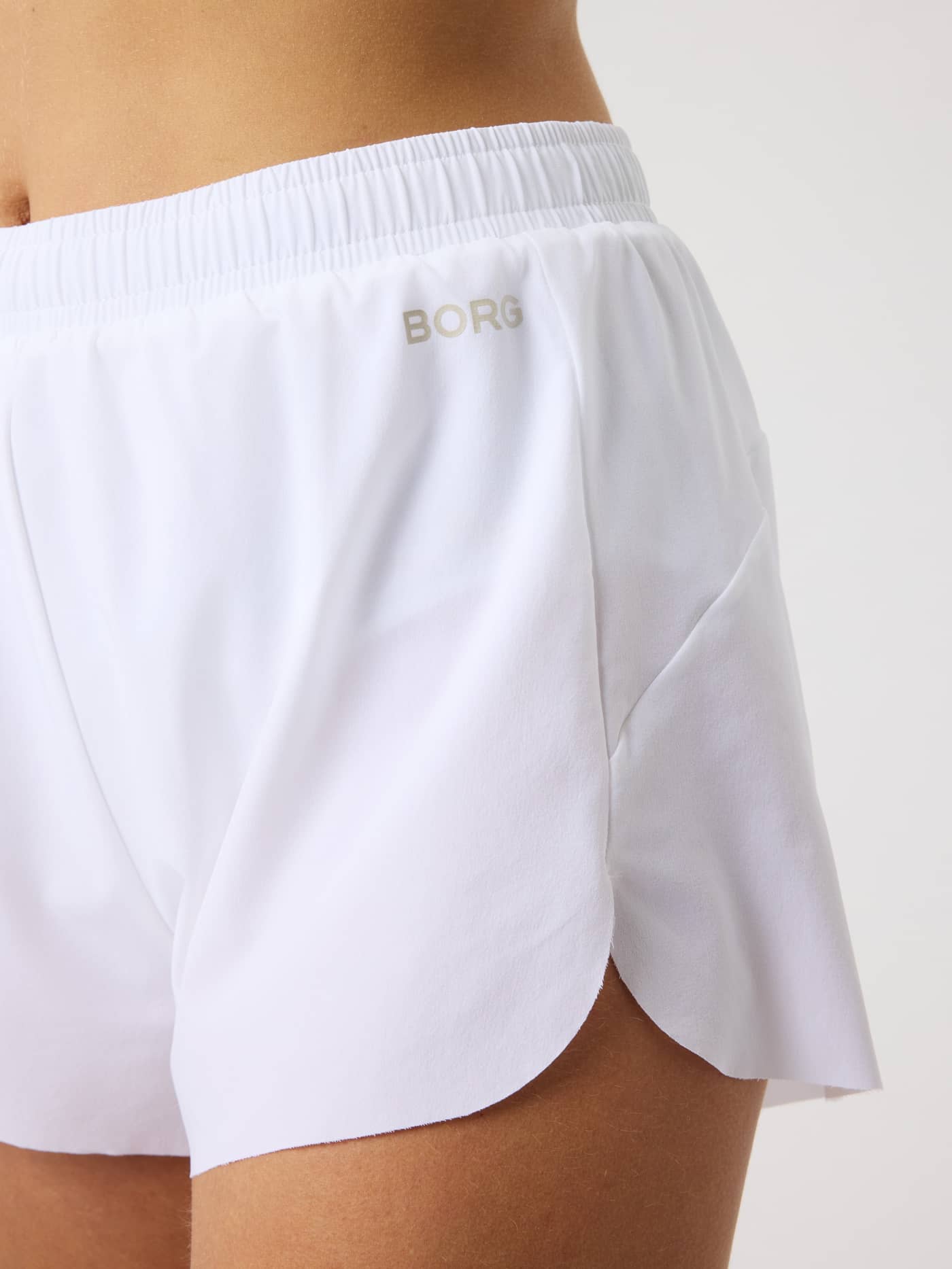 Close-up of the women's Borg Performance 2 In 1 Shorts in Brilliant White (White) for running with a silver reflective logo. - Image 5
