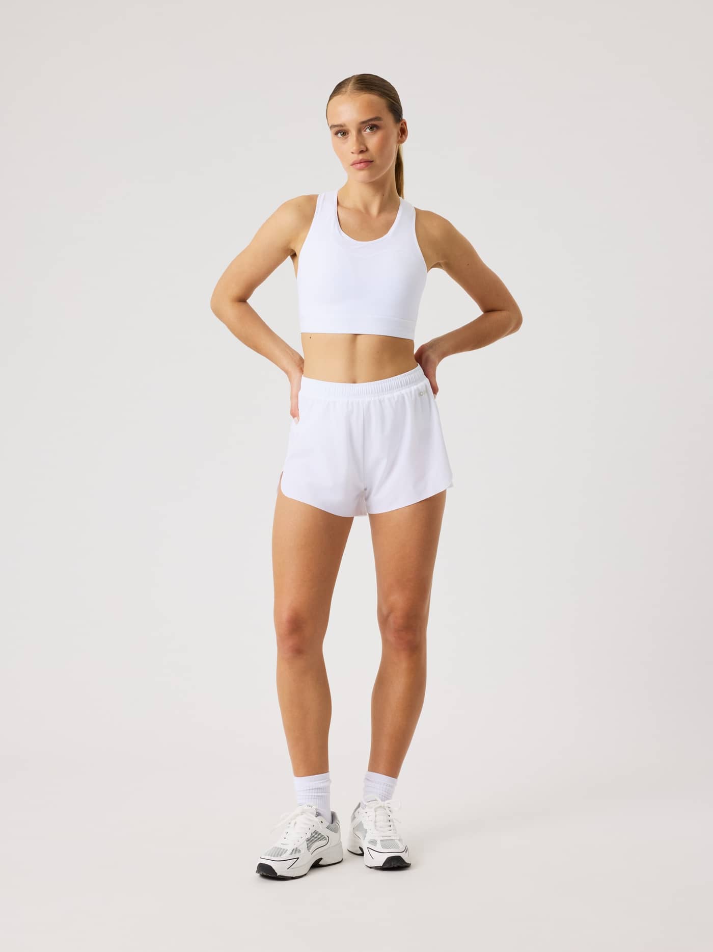 Full-body front view of a woman wearing the Borg Performance 2 In 1 Shorts in Brilliant White (White) for running. - Image 3