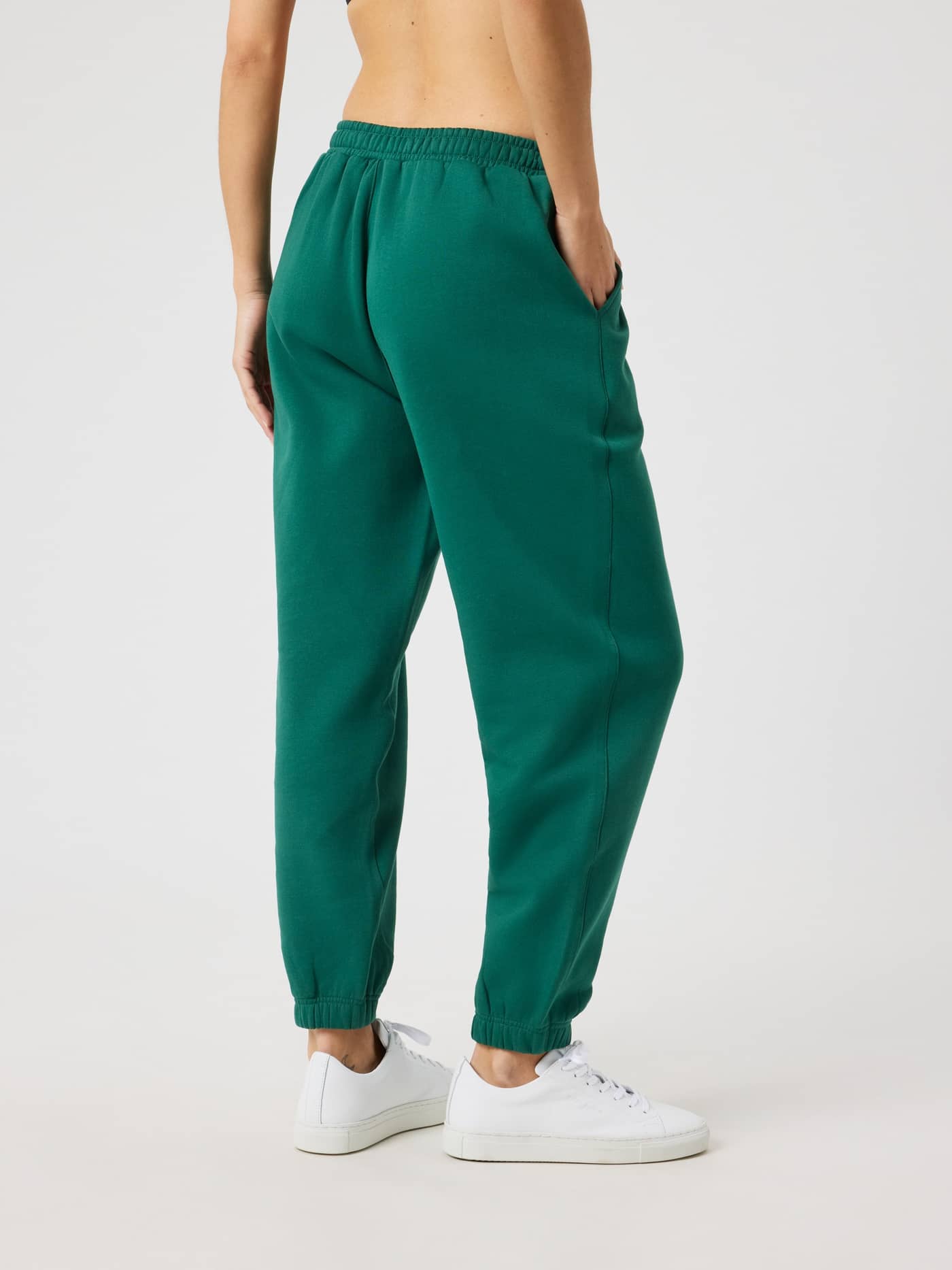 Side back view of a woman wearing Borg Sweatpants in Posy Green (Green) in a regular fit with a soft fleece interior. - Image 2