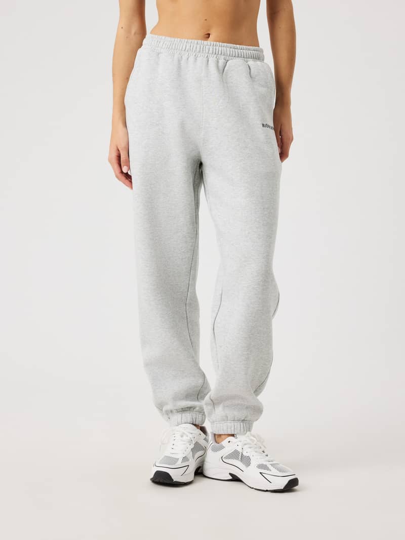 Front view of a woman wearing the regular fit Björn Borg Sweatpants in Ultra Light Grey Melange (Grey) with a black logo.