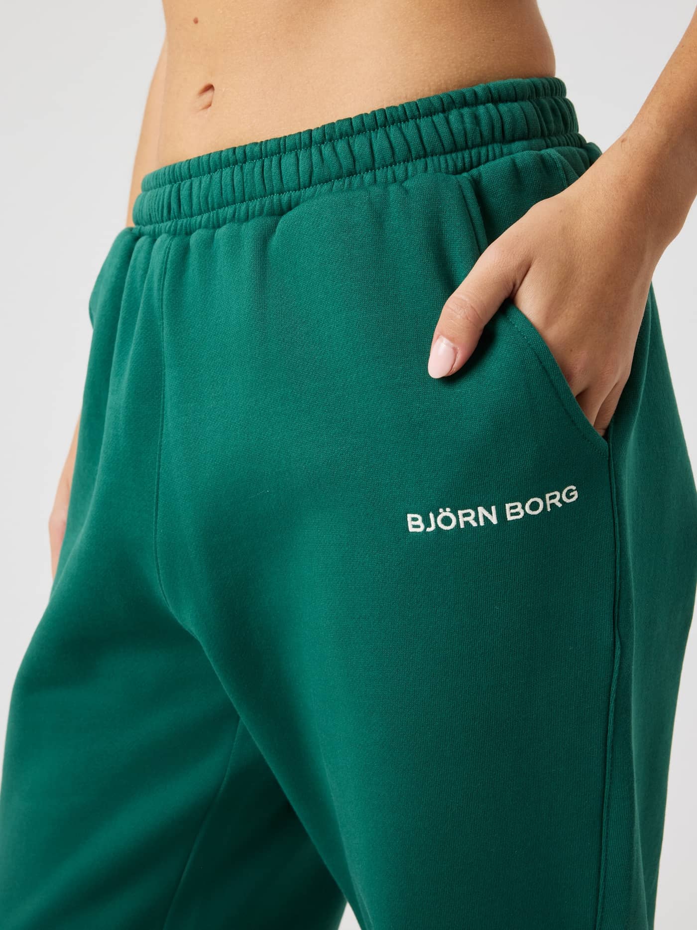 Close-up of Borg Sweatpants in Posy Green (Green) for women, featuring a regular fit, white logo and functional side pocket. - Image 4