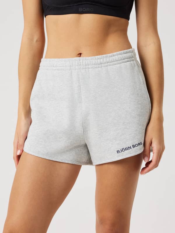 Front view of a woman wearing the cotton Borg Sweatshorts in Ultra Light Grey Melange (Grey) with a soft fit and black logo.