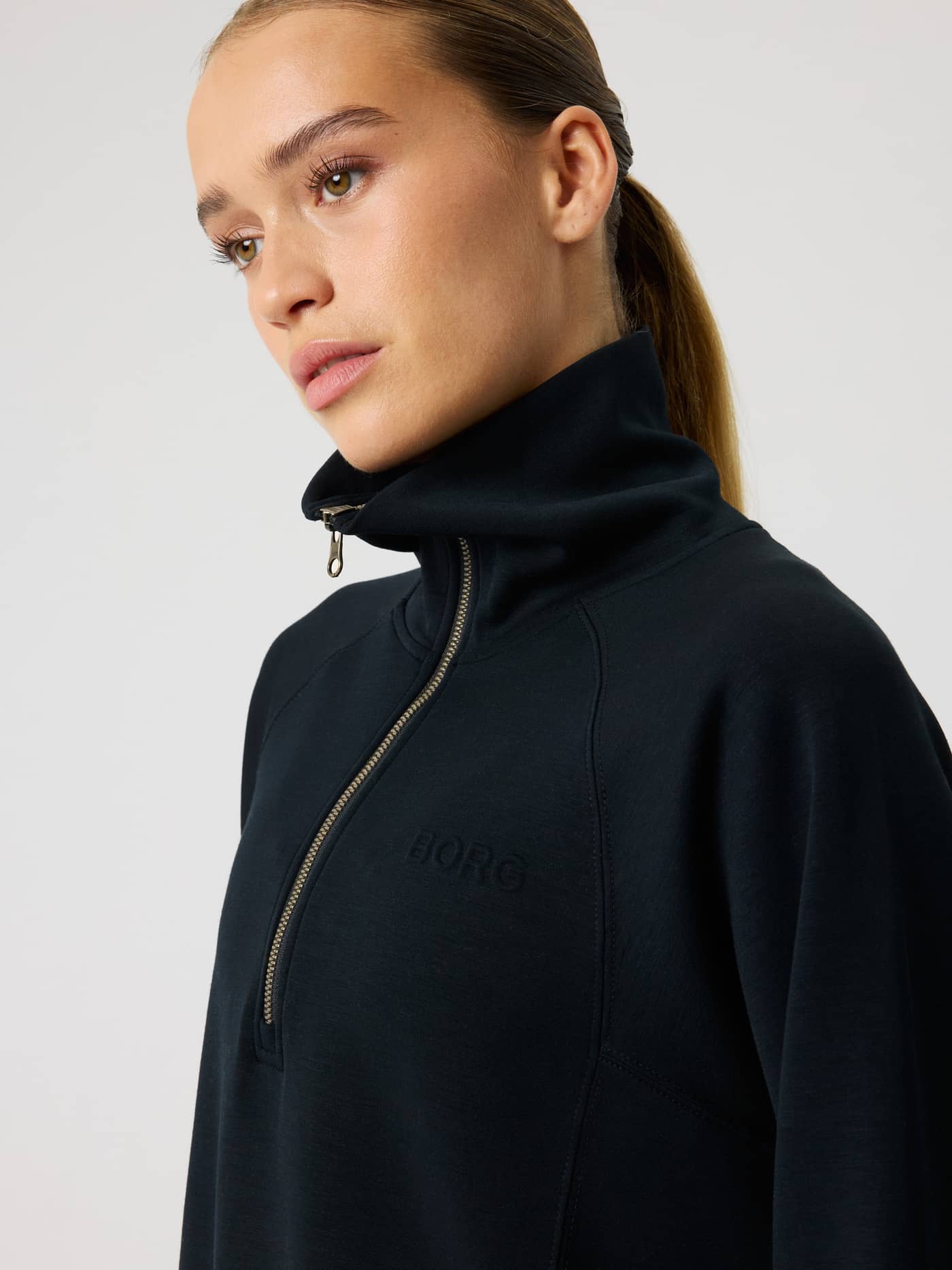 Close-up side view of the women's Studio Soft Halfzip Sweatshirt in Black Beauty (Black) with a tonal BORG logo. - Image 6