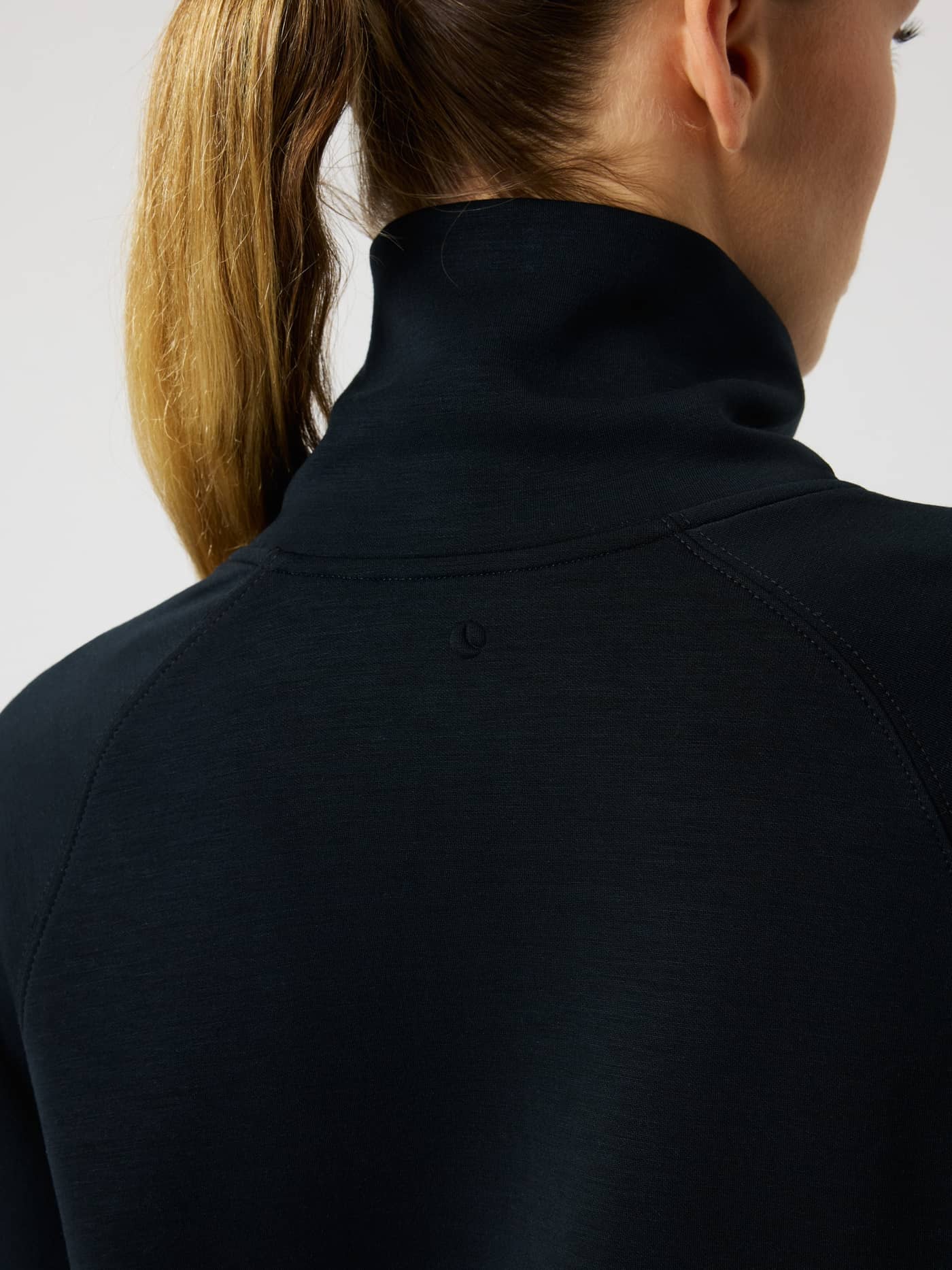 Close-up back view of the Studio Soft Halfzip Sweatshirt in Black Beauty (Black), showing the high collar and tonal logo. - Image 5
