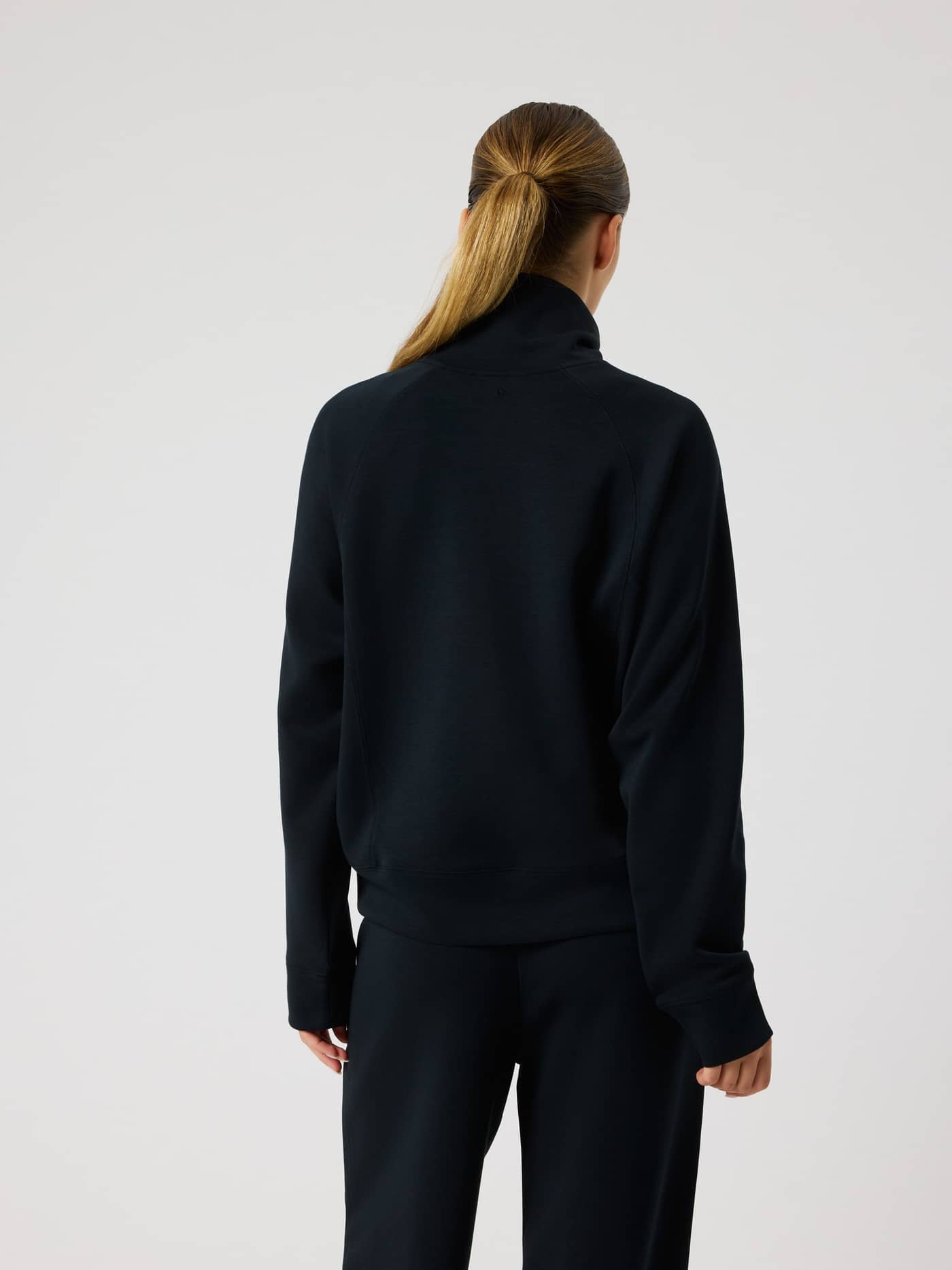 Back view of a model wearing the Studio Soft Halfzip Sweatshirt in Black Beauty (Black), featuring a loose fit and soft feel. - Image 2