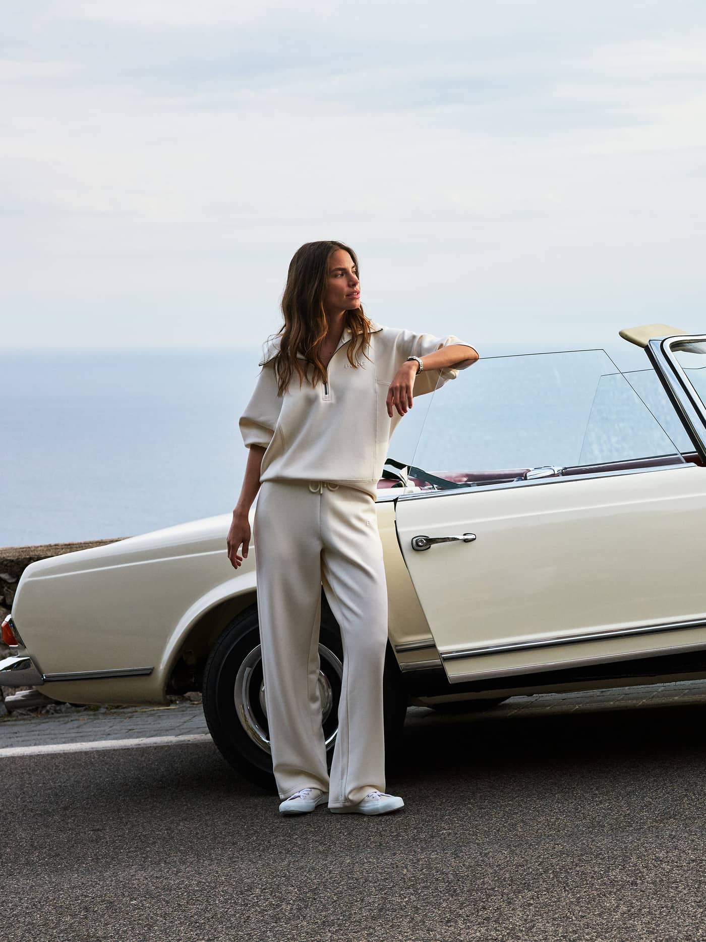 Studio Soft Halfzip Sweatshirt in Tofu (White) with a stylish loose fit, worn by a woman next to a vintage car. - Image 2