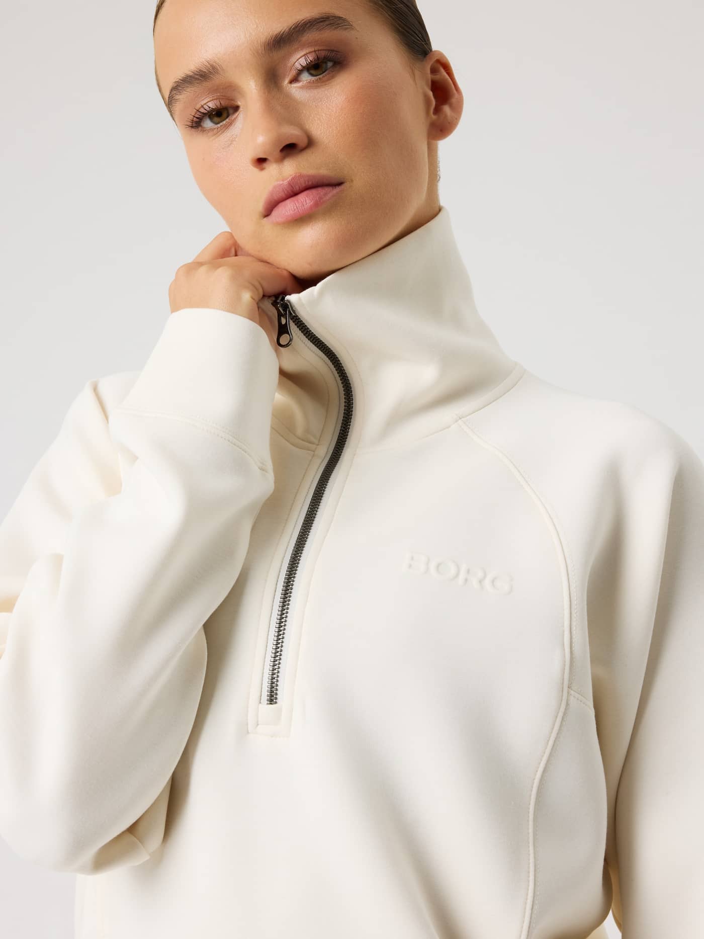 Front close-up of the loose fit Studio Soft Halfzip Sweatshirt in Tofu (White) with a high collar and white BORG logo. - Image 3
