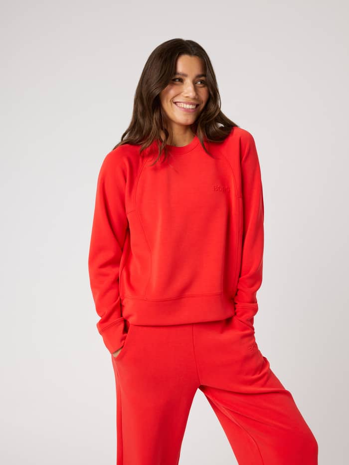 Front view of a model wearing the Björn Borg Studio Soft Sweatshirt in Flame Scarlet (Red), featuring raglan sleeves.