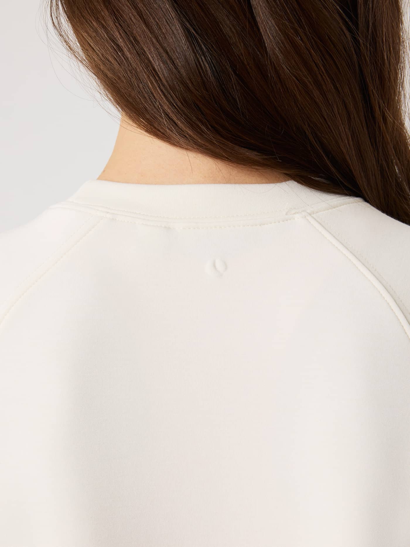 Vue arrière du Studio Soft Sweatshirt en Tofu (Blanc) avec un logo gaufré et des manches raglan. - Image 4