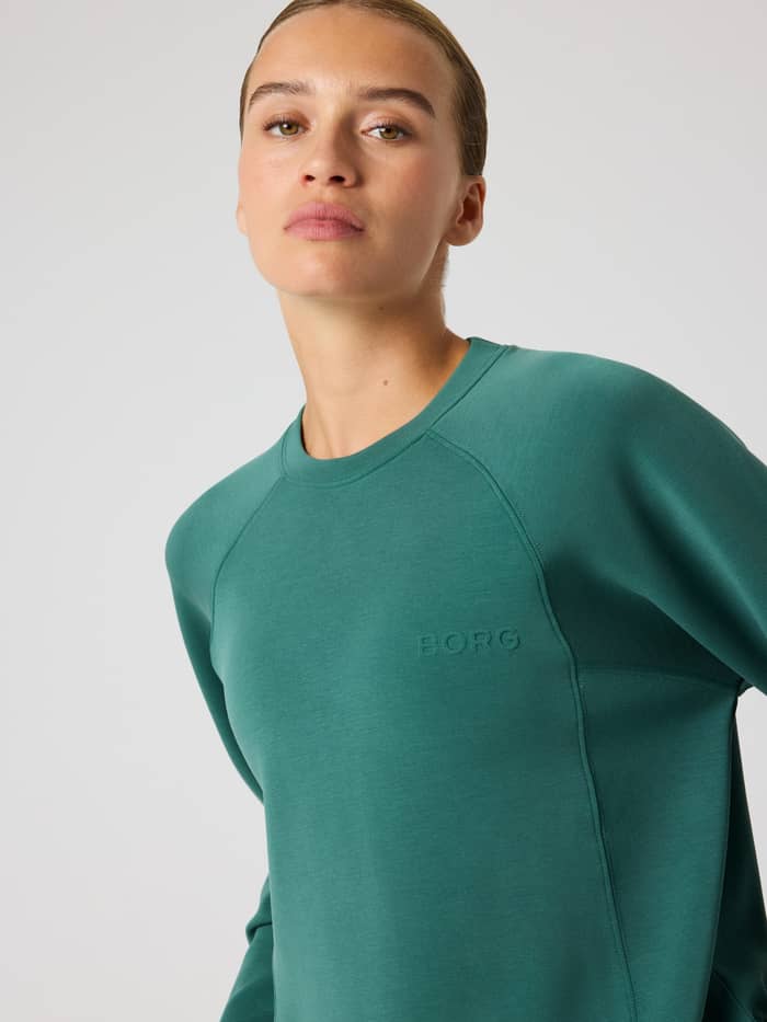 Vorderansicht eines Models im Studio Soft Sweatshirt in Mallard Green (Grün) mit einem tonalen BORG-Logo auf der Brust. - Image 4