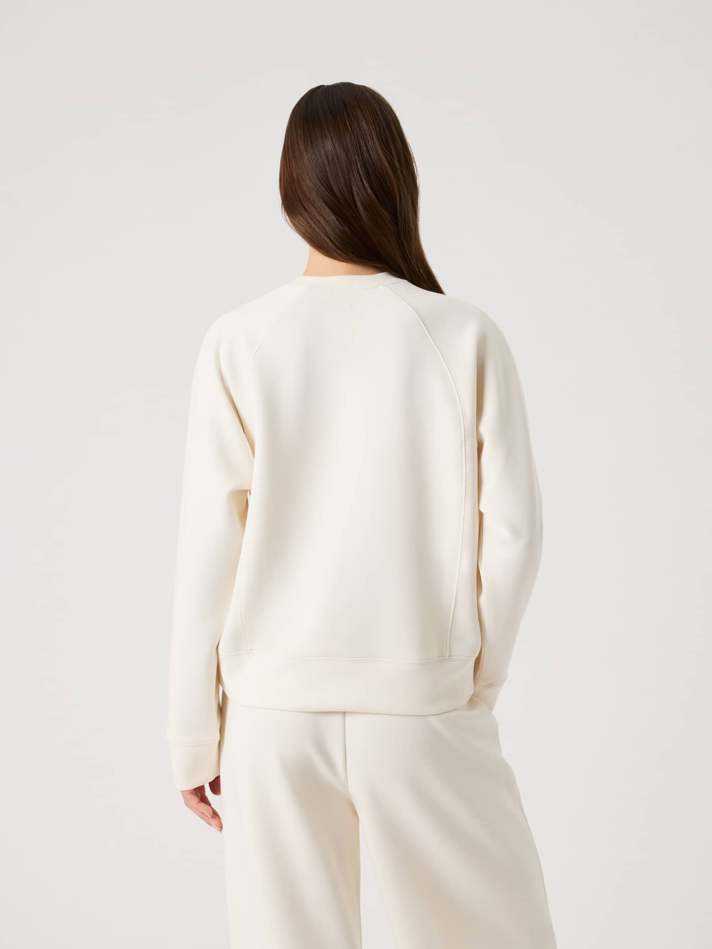 Vue arrière d'une femme portant le Studio Soft Sweatshirt en Tofu (Blanc) avec des manches raglan décontractées. - Image 2