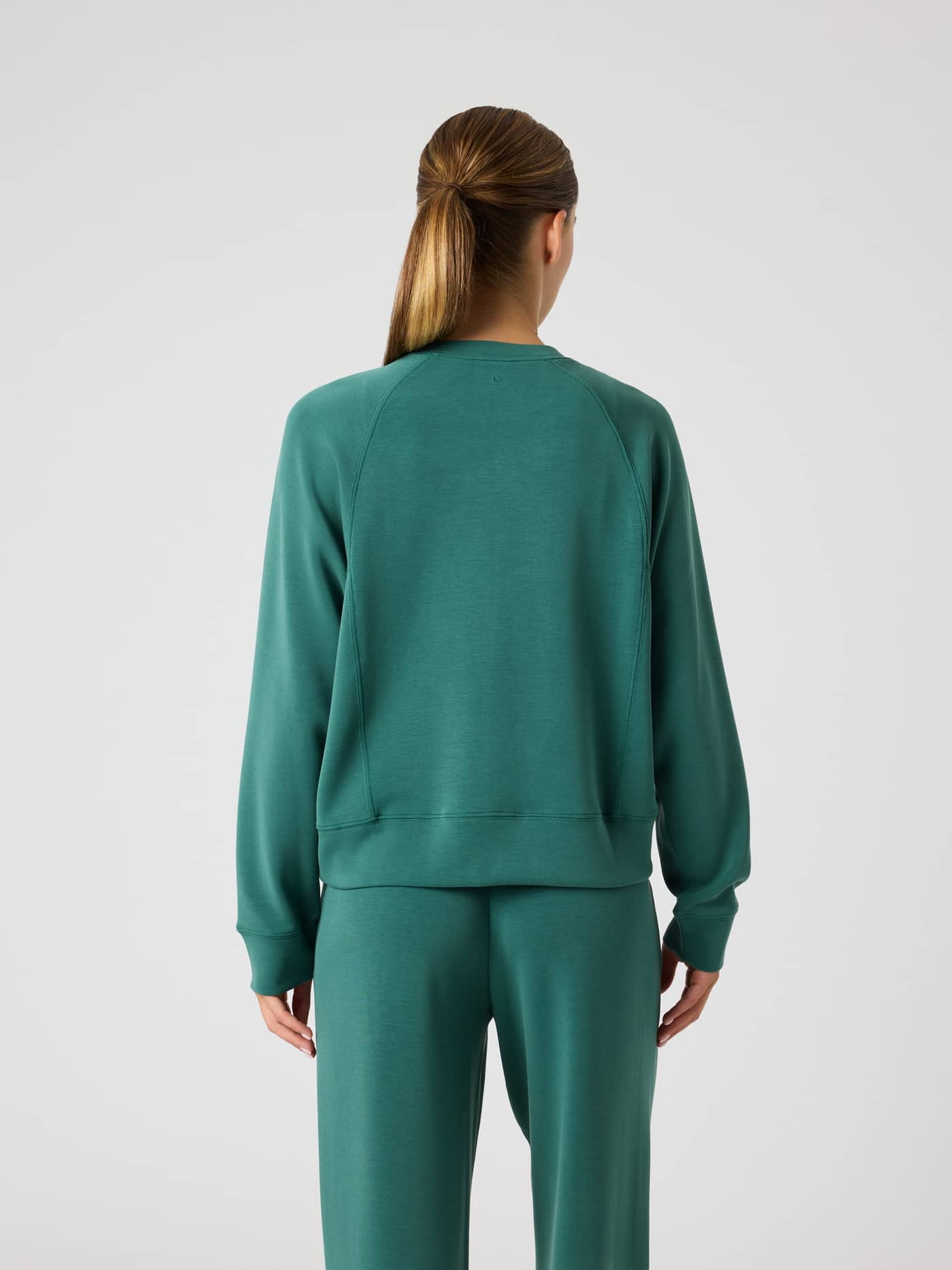 Back view of a woman wearing the Björn Borg Studio Soft Sweatshirt in Mallard Green (Green), featuring a relaxed fit. - Image 3