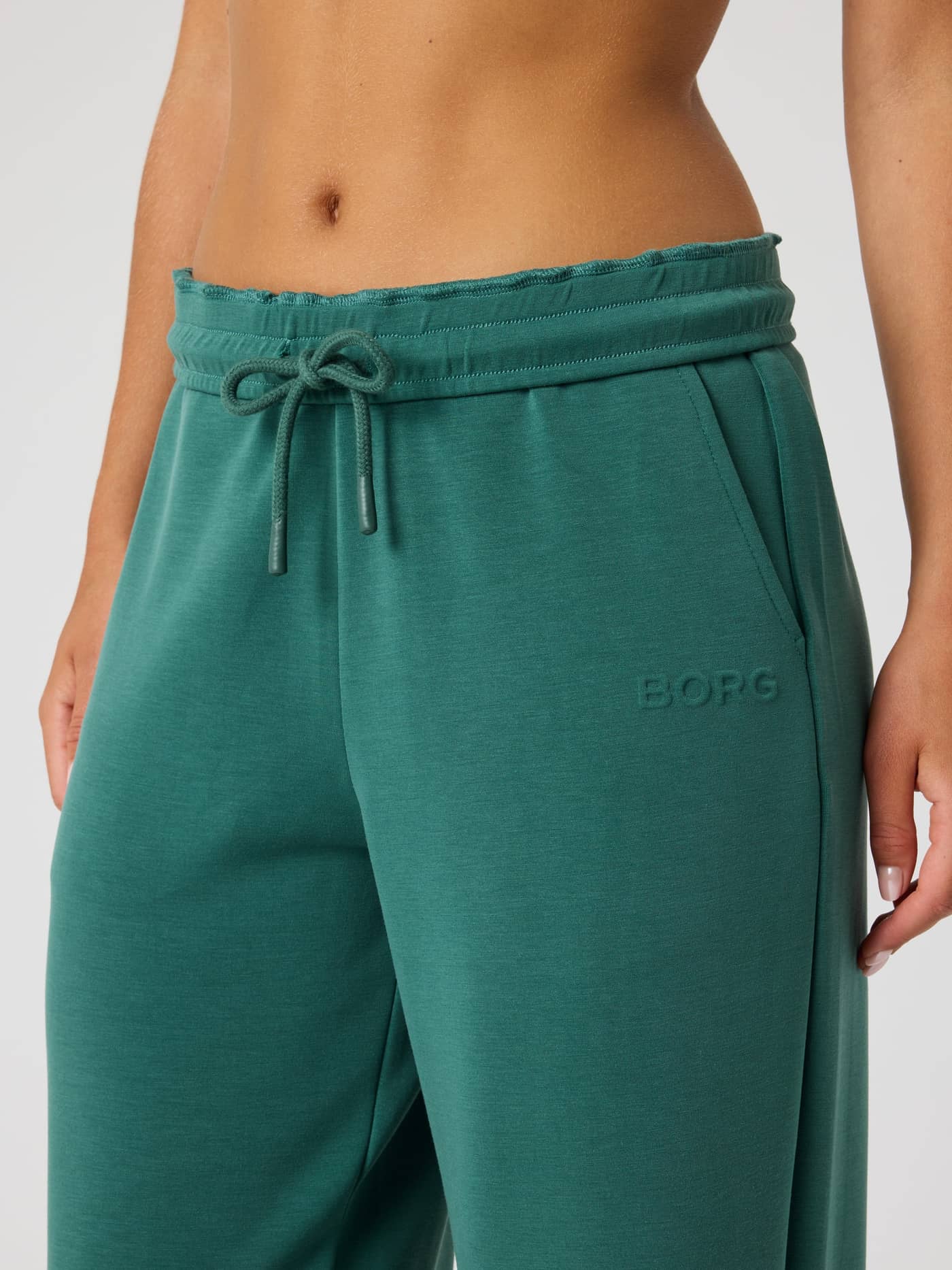 Detailansicht der Studio Soft Sweatpants in Mallard Green (Grün) mit Kordelzug und grünem BORG-Logo für Damen. - Image 5