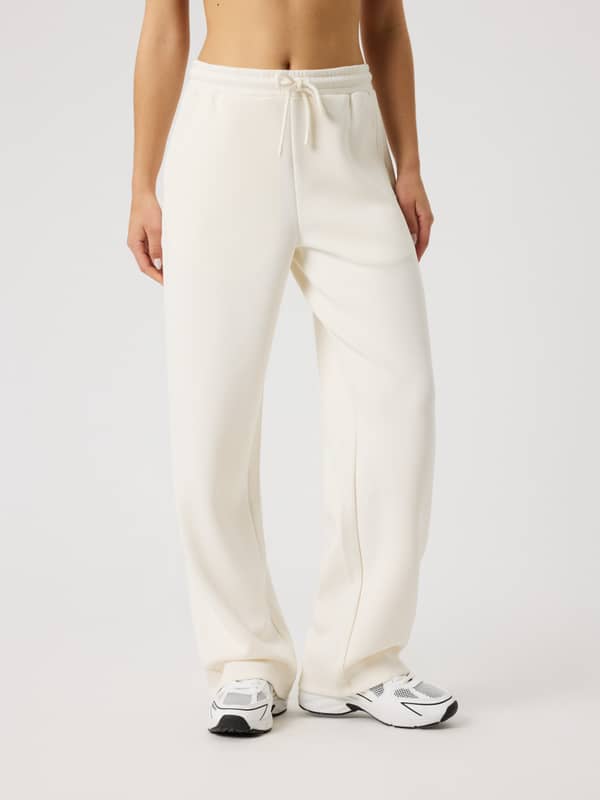 Front view of a woman wearing the Björn Borg Studio Soft Sweatpants in Tofu (White) with an adjustable drawstring.