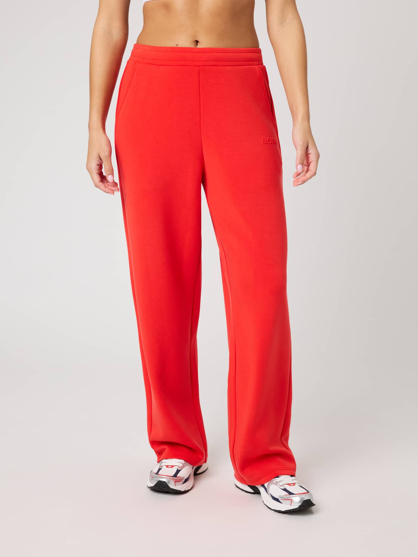 Front view of a model wearing Studio Soft Sweatpants in Flame Scarlet (Red) with a relaxed fit and tone-on-tone logo. - Image 3