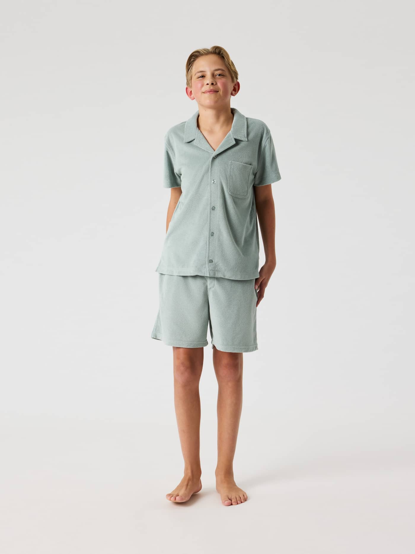 Front view of a kid wearing the Slate Gray (Green) Borg Toweling Pool Shirt, featuring a regular fit and absorbent material. - Image 3