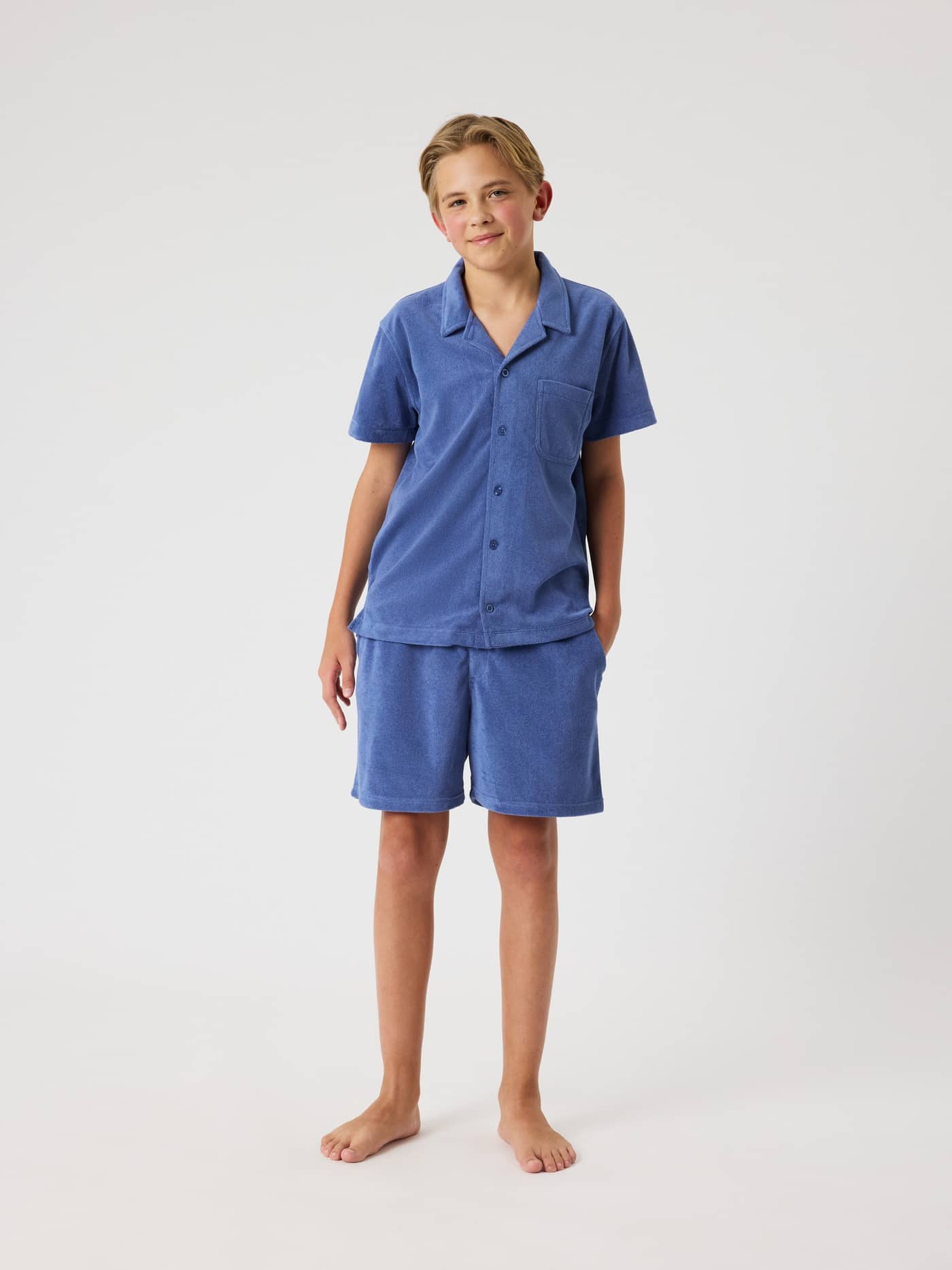 Full-body front view of a kid wearing the soft, regular fit Björn Borg Toweling Pool Shirt in Coastal Fjord (Blue). - Image 3