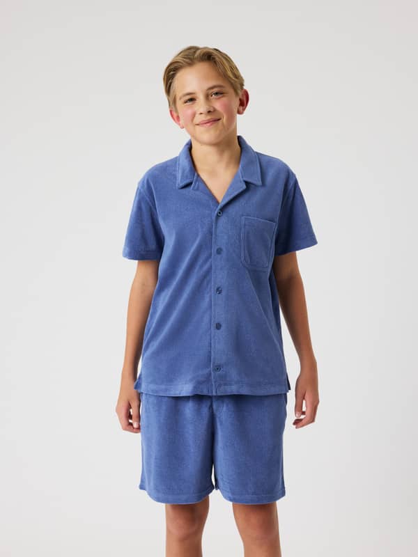 Borg Toweling Pool Shirt i Coastal Fjord (Blå) set forfra på en kid i et blødt frottémateriale.
