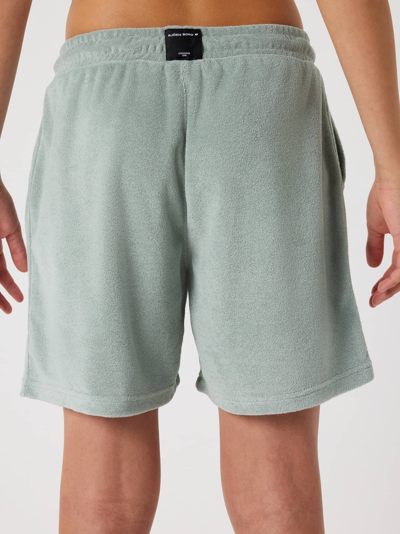 Back view of a model wearing the Borg Toweling Pool Shorts for kids in Slate Gray (green) with a soft plush finish. - Image 2
