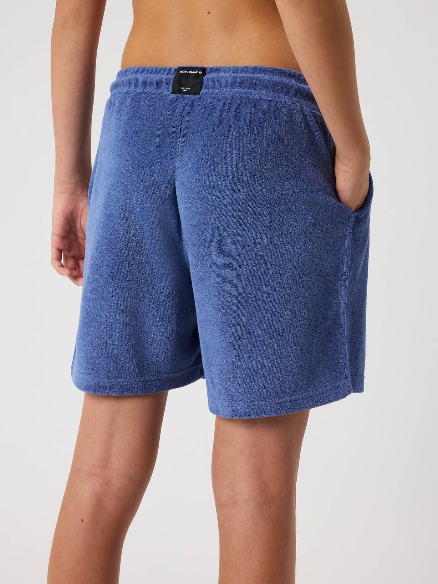 Back view of kids wearing the regular fit Borg Toweling Pool Shorts in Coastal Fjord (Blue), featuring a woven logo label. - Image 2