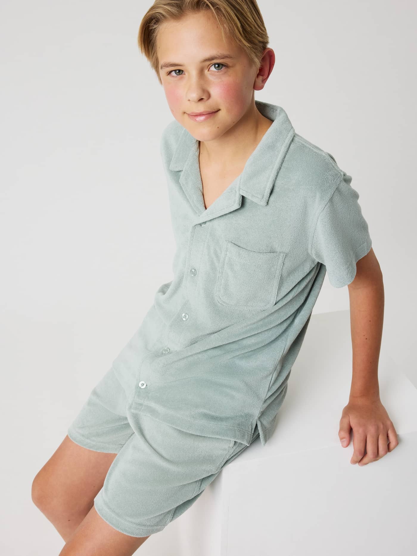 Front view of a kid wearing the Slate Gray (Green) Borg Toweling Pool Shorts in a soft toweling fabric. - Image 4