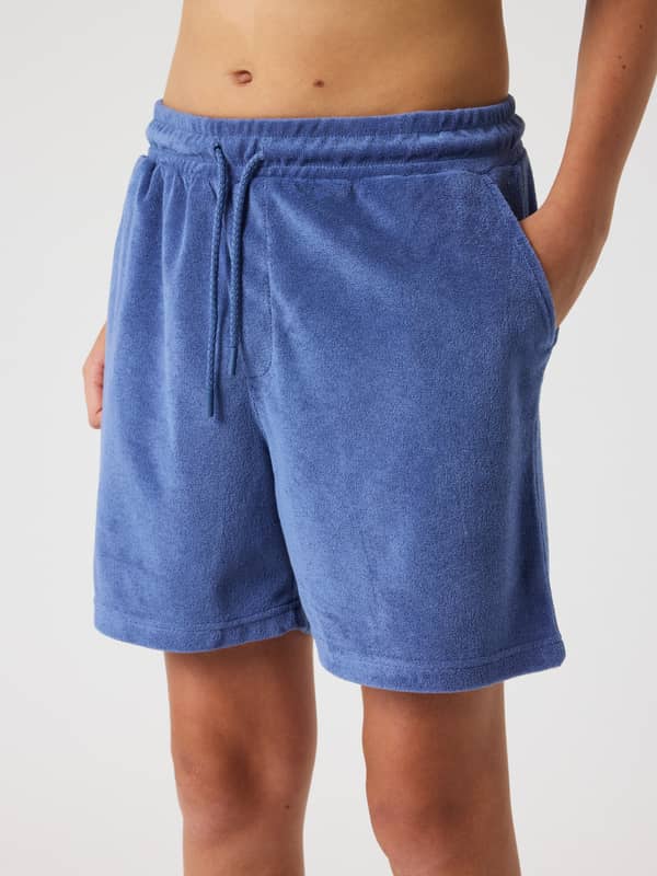 Front view of a model wearing kids' Borg Toweling Pool Shorts in Coastal Fjord (Blue) with a regular fit and soft finish.