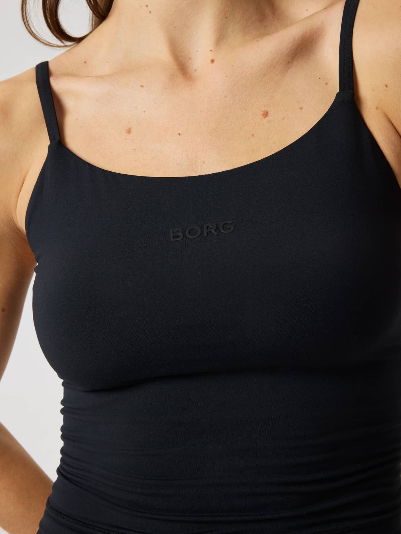 Close-up van de slim-fit Studio Soft Cropped Tank Top in Black Beauty (Zwart) met een zwart BORG-logo voor training. - Image 5