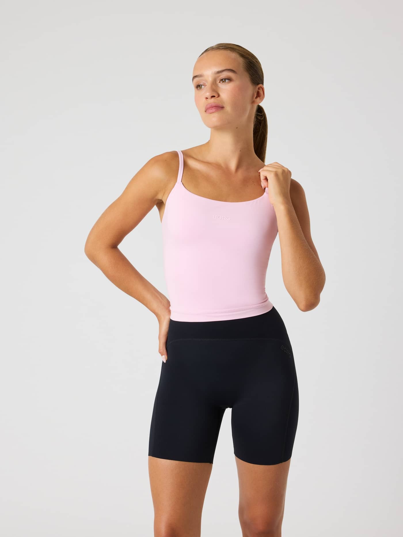 Front view of a model wearing the slim-fit Studio Soft Cropped Tank Top in Pink Lady (Pink) for training. - Image 2
