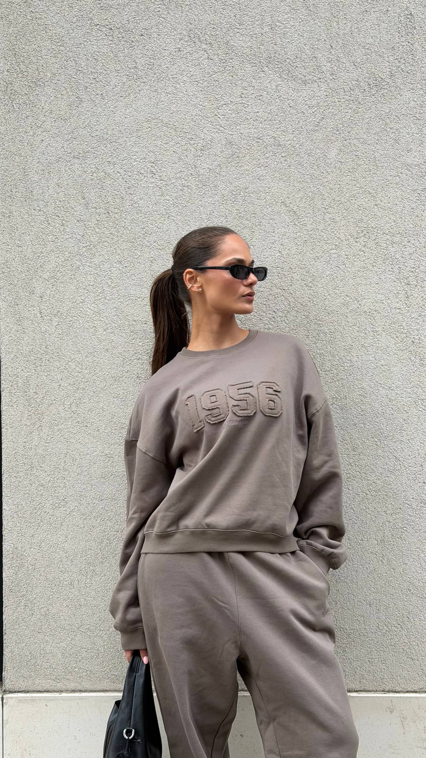 Waist-up view of a model wearing the Björn Borg Studio Oversized Sweatshirt in Falcon (Brown) with a tonal 1956 logo. - Image 1