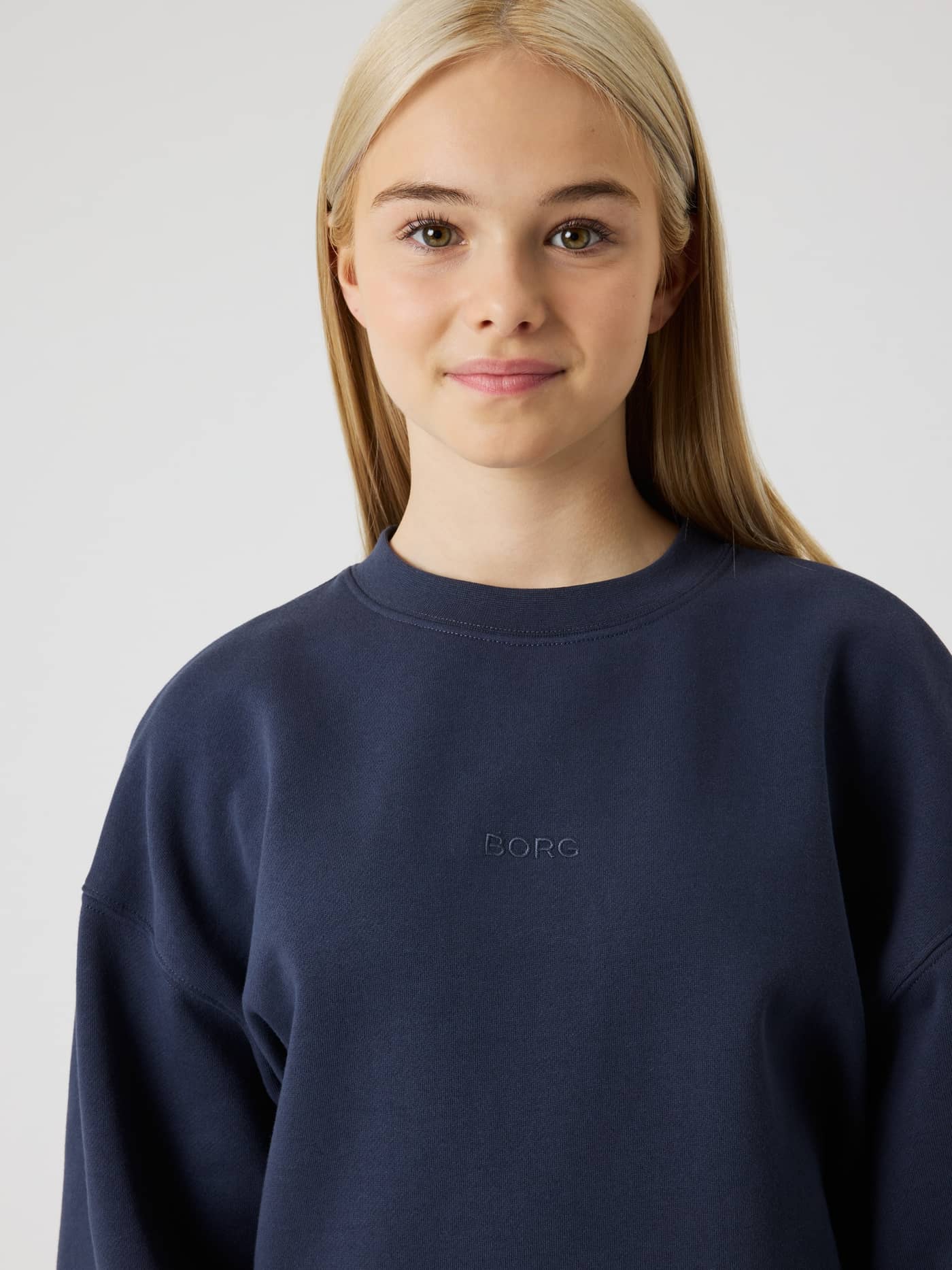 Front view of a kid wearing the Borg Oversized Sweatshirt in Odyssey Gray (Navy) with a tonal chest logo. - Image 5