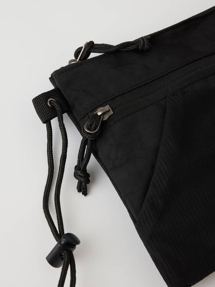 Detail of the Borg Explorer Crossover Bag in Black Beauty (Black) showing the zipper pocket and mesh for training. - Image 3