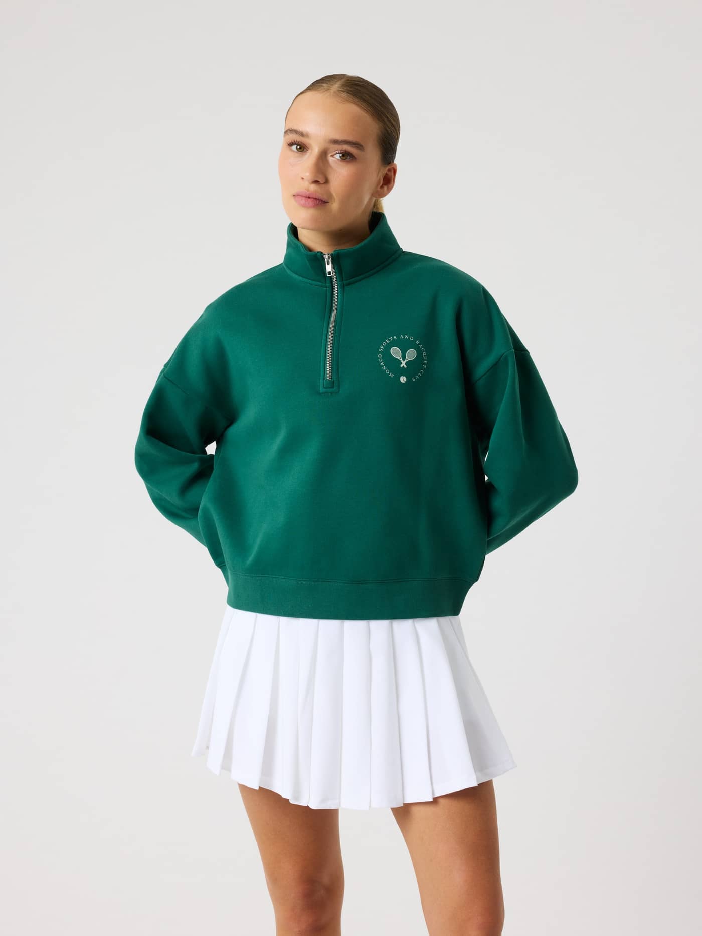 Borg Halfzip Sweatshirt i Posy Green (Grønn) sett forfra, stilig tennisstil med hvit logo og hvitt skjørt. - Image 2