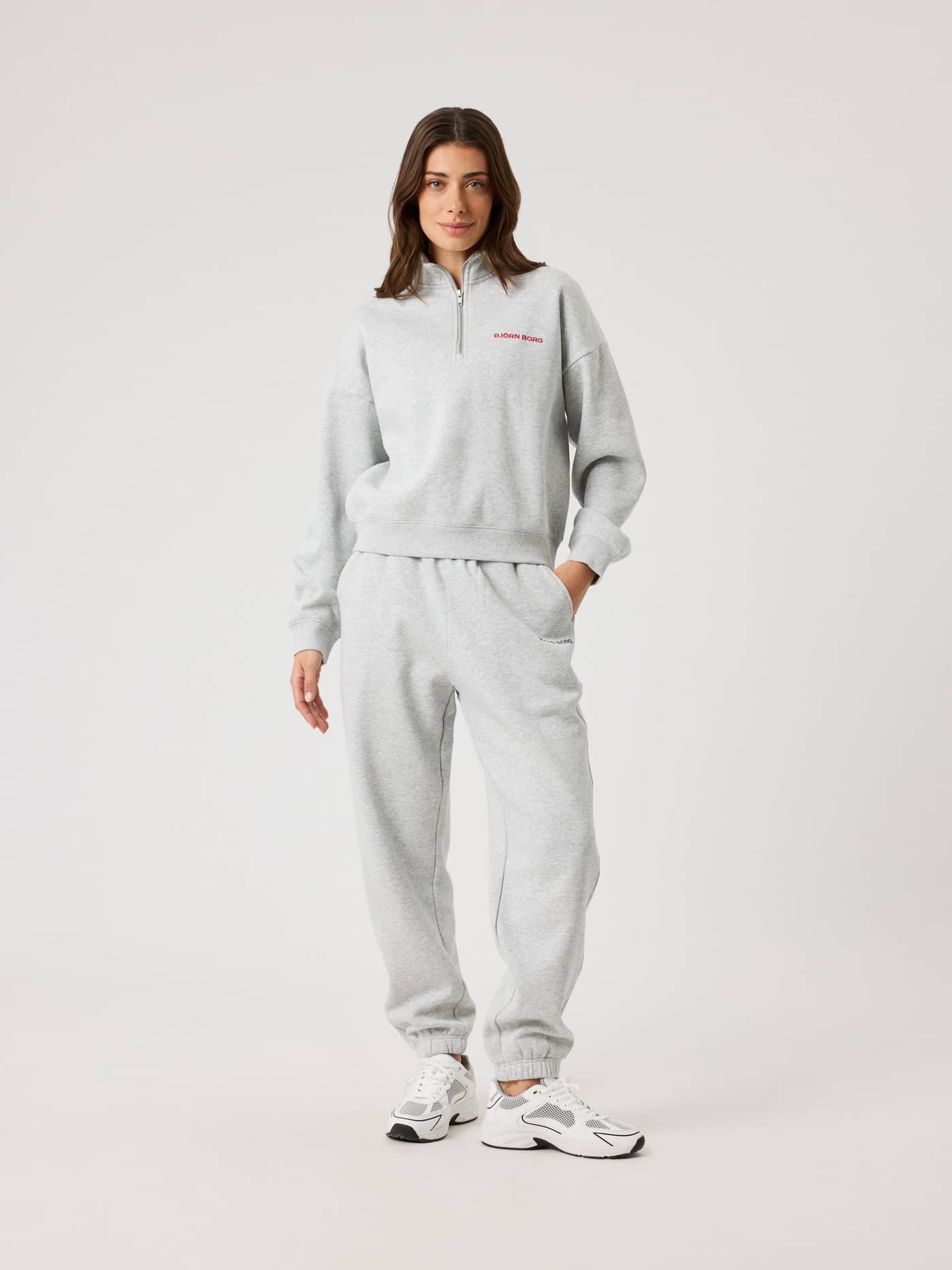 Full-body front view of a woman in the regular fit Ultra Light Grey Melange (Grey) Borg Halfzip Sweatshirt with a red logo. - Image 5