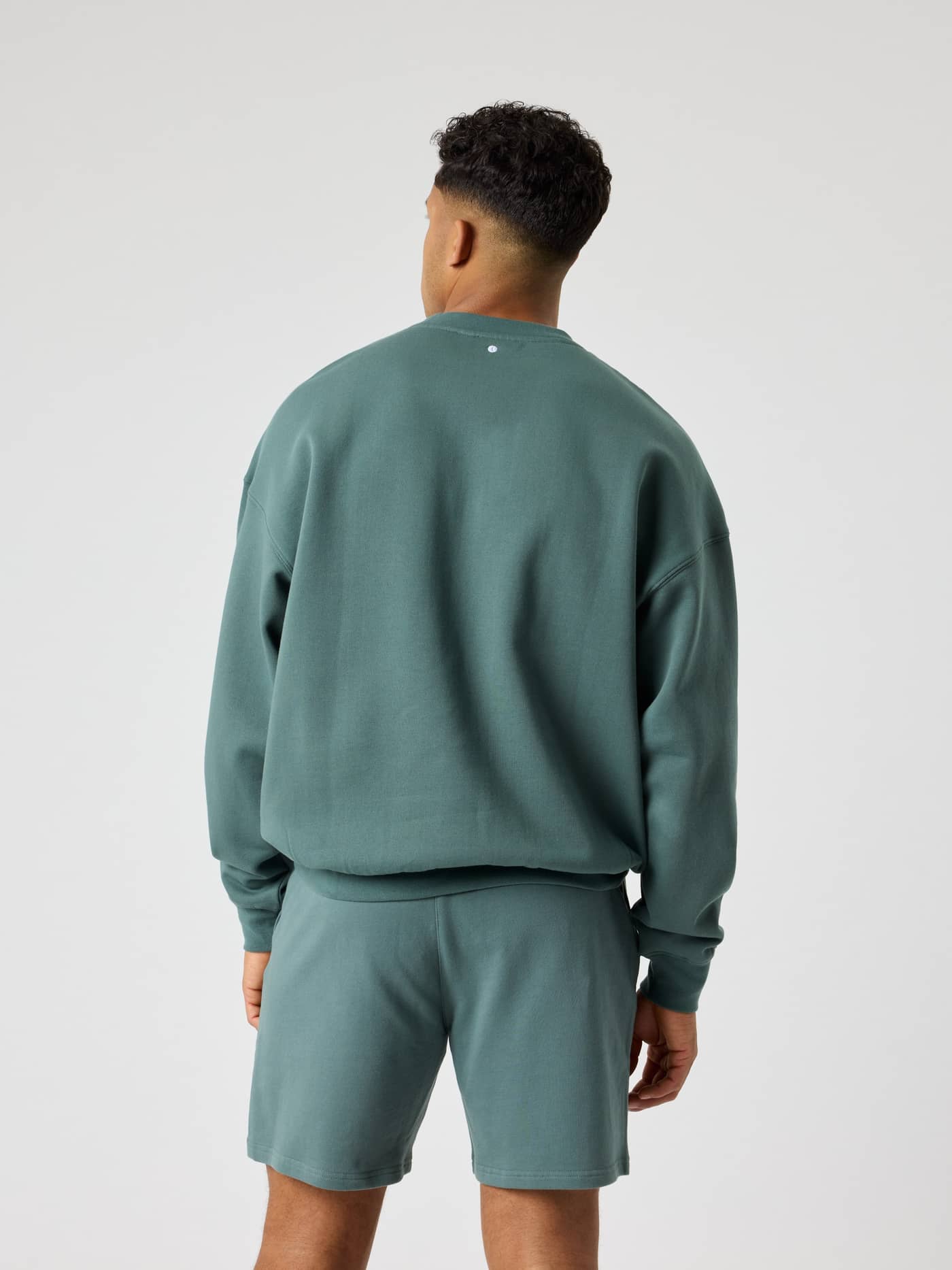 Rückansicht eines Mannes im Borg Oversized Logo Sweatshirt in Balsam Green (Grün) aus Baumwolle mit Tennisball-Print. - Image 3