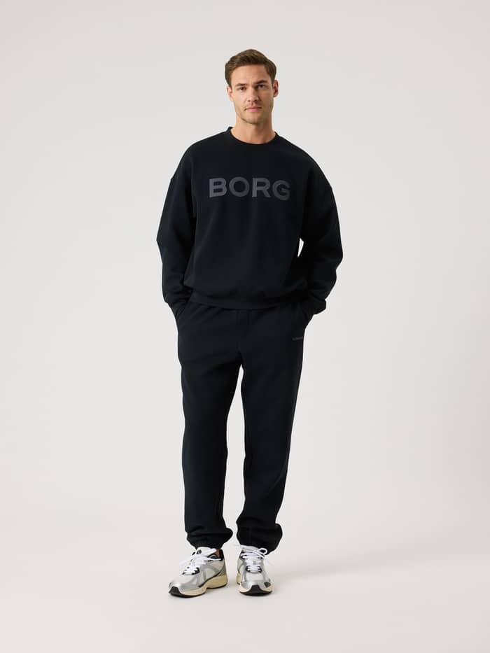 Vooraanzicht van een man in de Borg Oversized Logo Sweatshirt in Black Beauty (Zwart) van katoenmix met een grijs logo. - Image 3