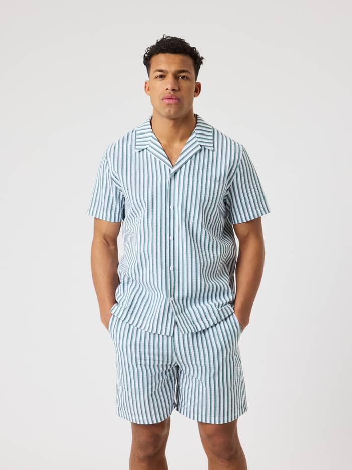 Front view of a man wearing the striped organic cotton Björn Borg Seersucker Resort Shirt in 7 Stripe 1 (Green/White).