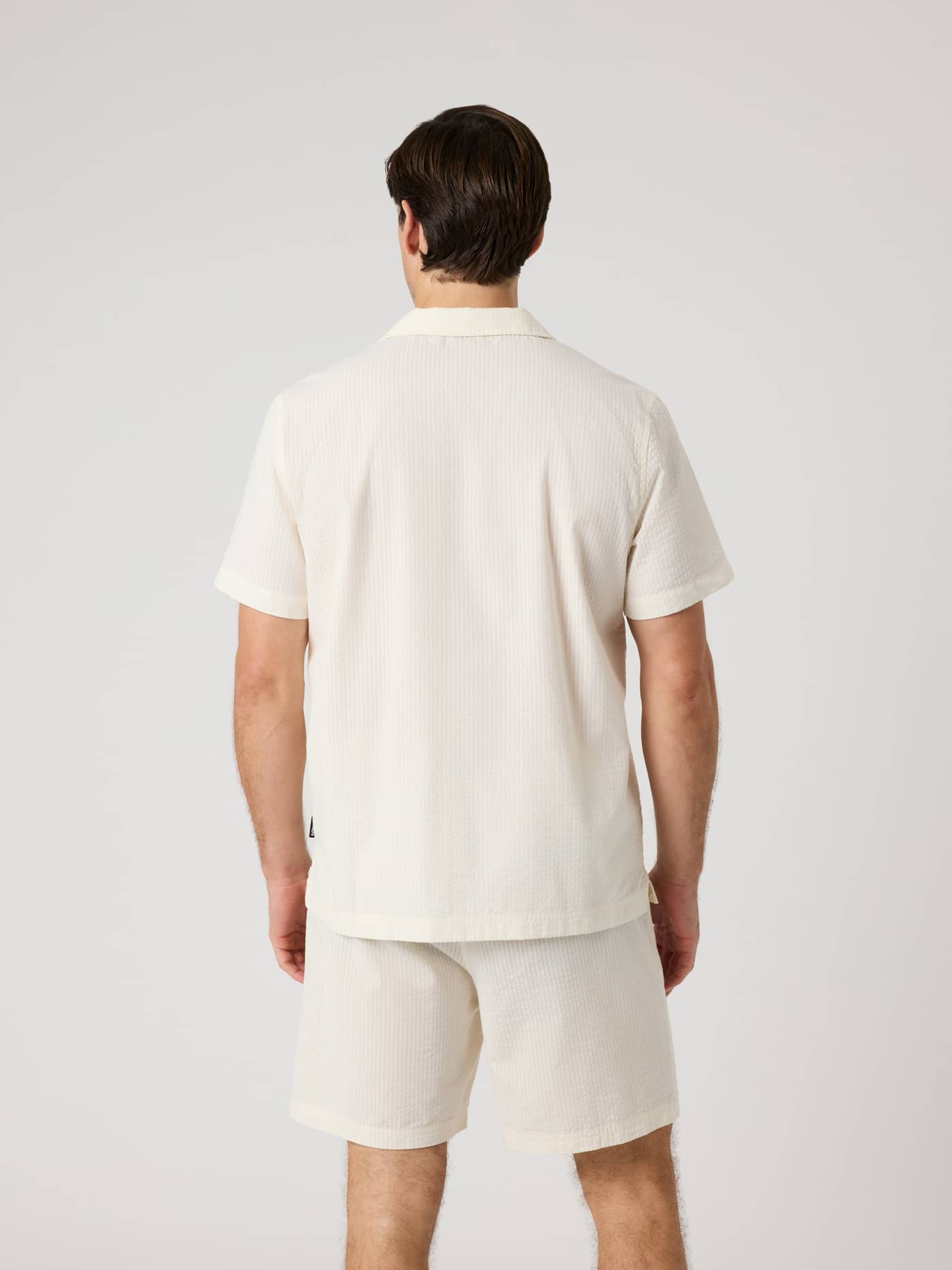 Back view of a man wearing the Borg Seersucker Resort Shirt in Tofu (White), featuring a textured seersucker weave. - Image 3