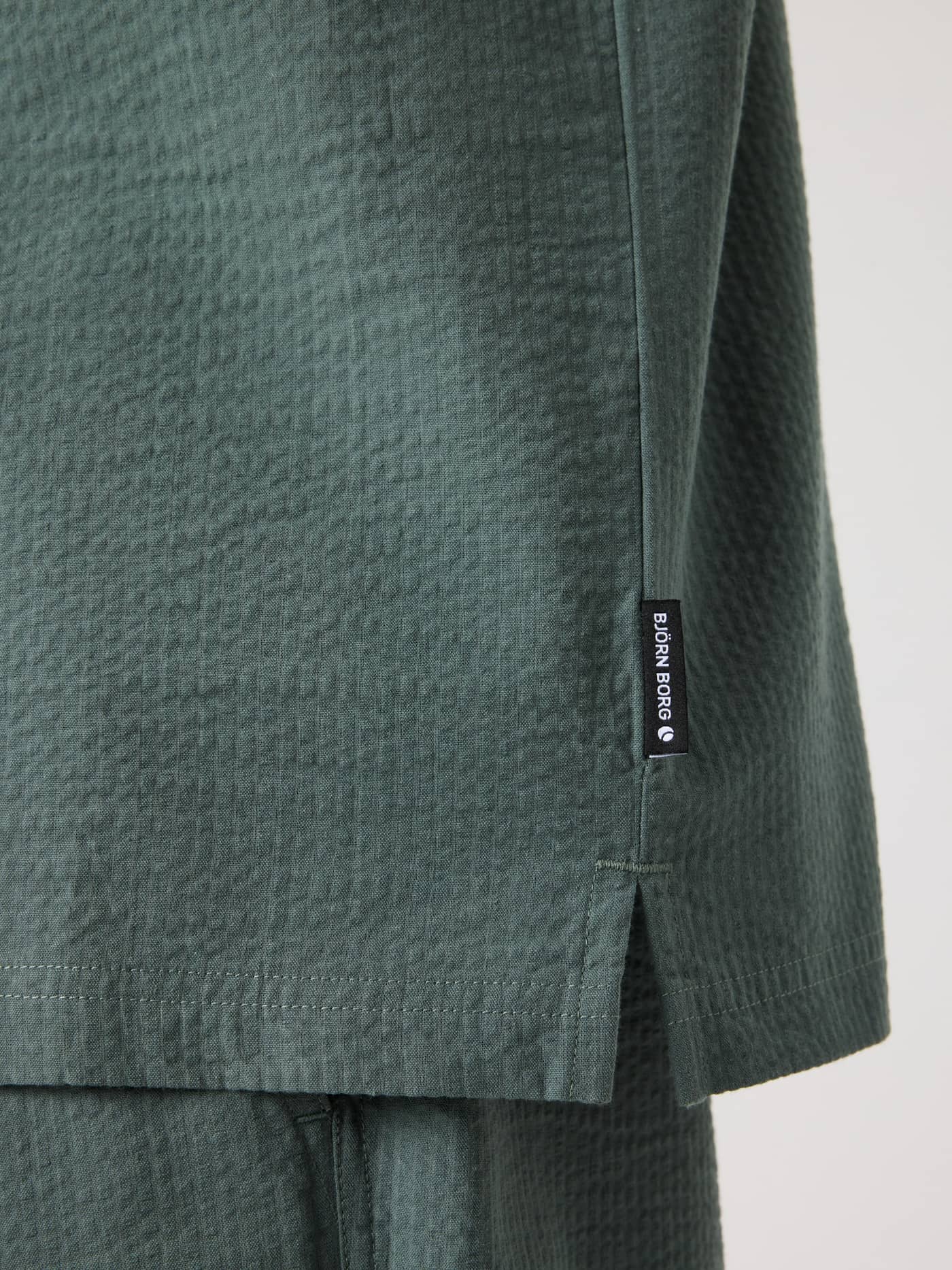 Primer plano de la Borg Seersucker Resort Shirt en Balsam Green (Verde) con etiqueta de logo blanca y abertura lateral. - Image 5