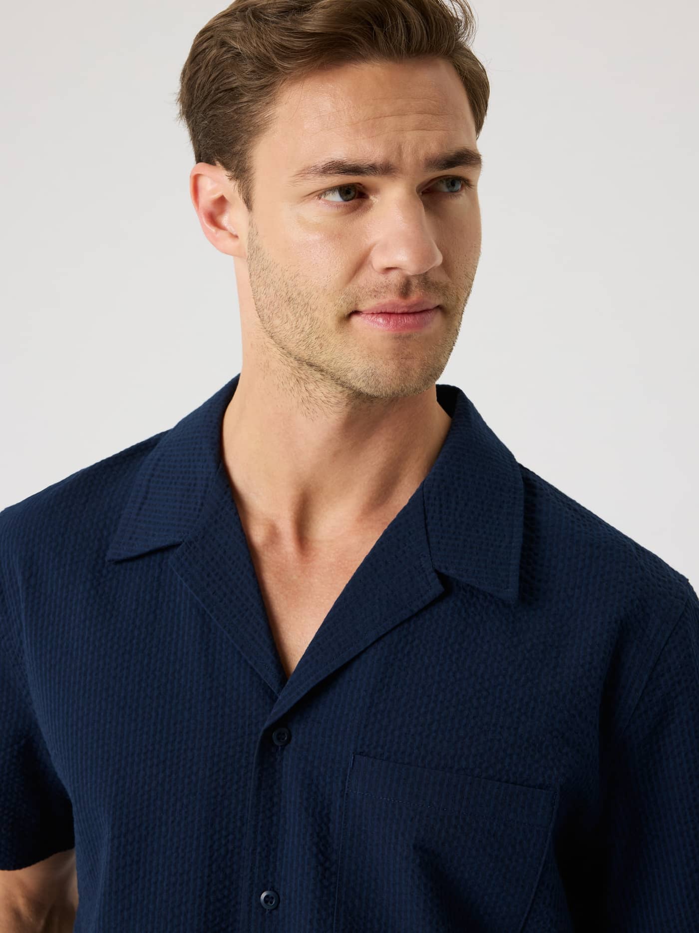 Close-up of a man wearing the Night sky (Navy) Borg Seersucker Resort Shirt with a textured seersucker weave. - Image 5