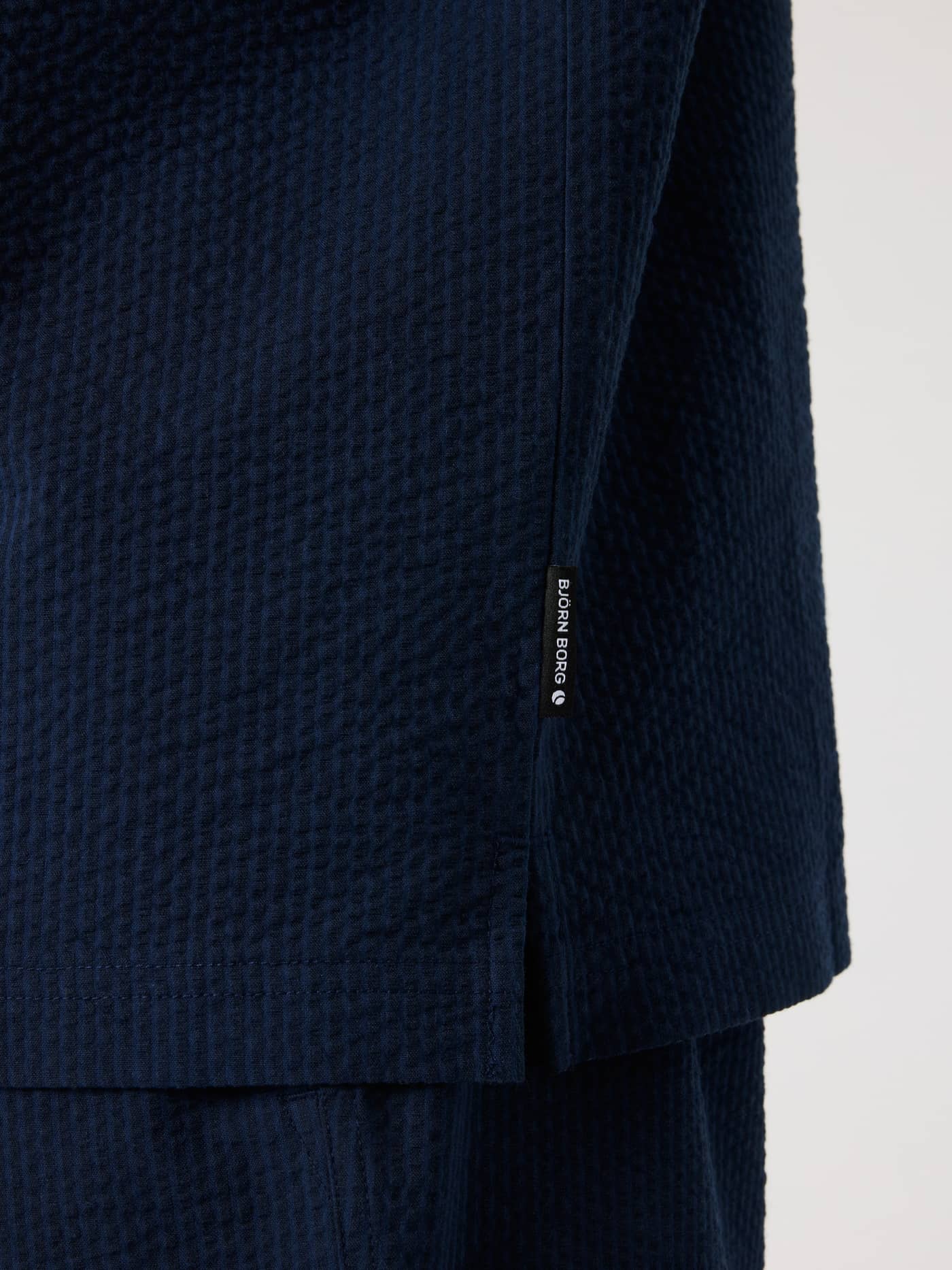 Night sky (Navy) Borg Seersucker Resort Shirt close-up, showing the seersucker texture and logo flag label. - Image 6
