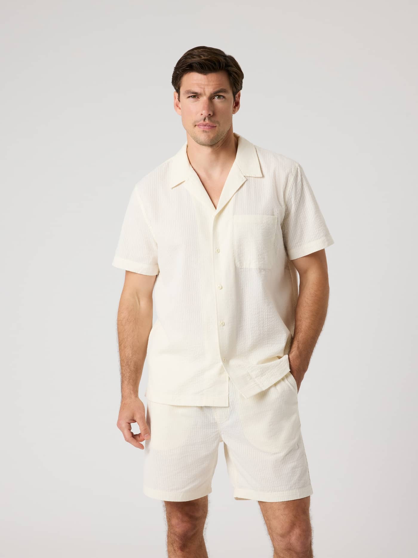 Front view of a man wearing the Borg Seersucker Resort Shirt in Tofu (White) with a textured organic cotton finish. - Image 2