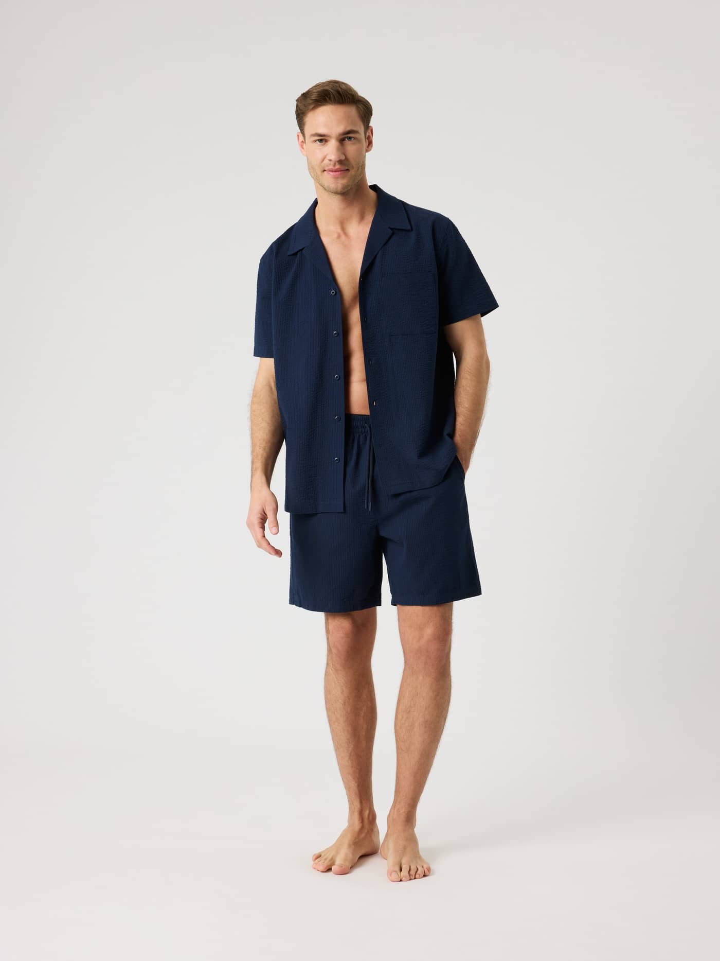 Full-body front view of a man wearing the Night sky (Navy) Borg Seersucker Resort Shirt in a textured organic cotton. - Image 3