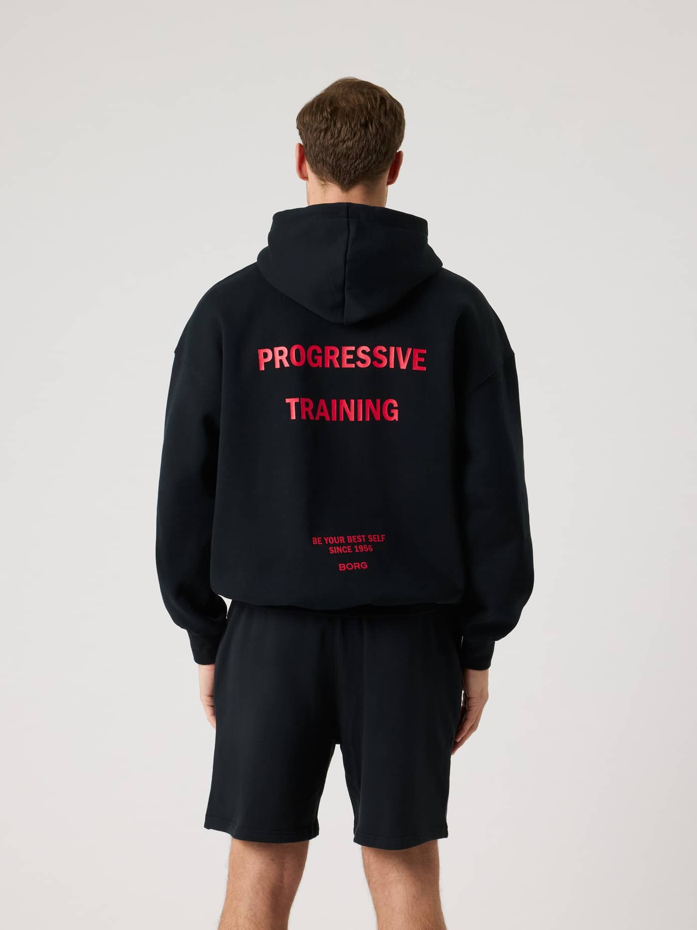Borg Oversized Hoodie i Black Beauty (Sort) set bagfra med rød træningsgrafik og en oversized pasform. - Image 1