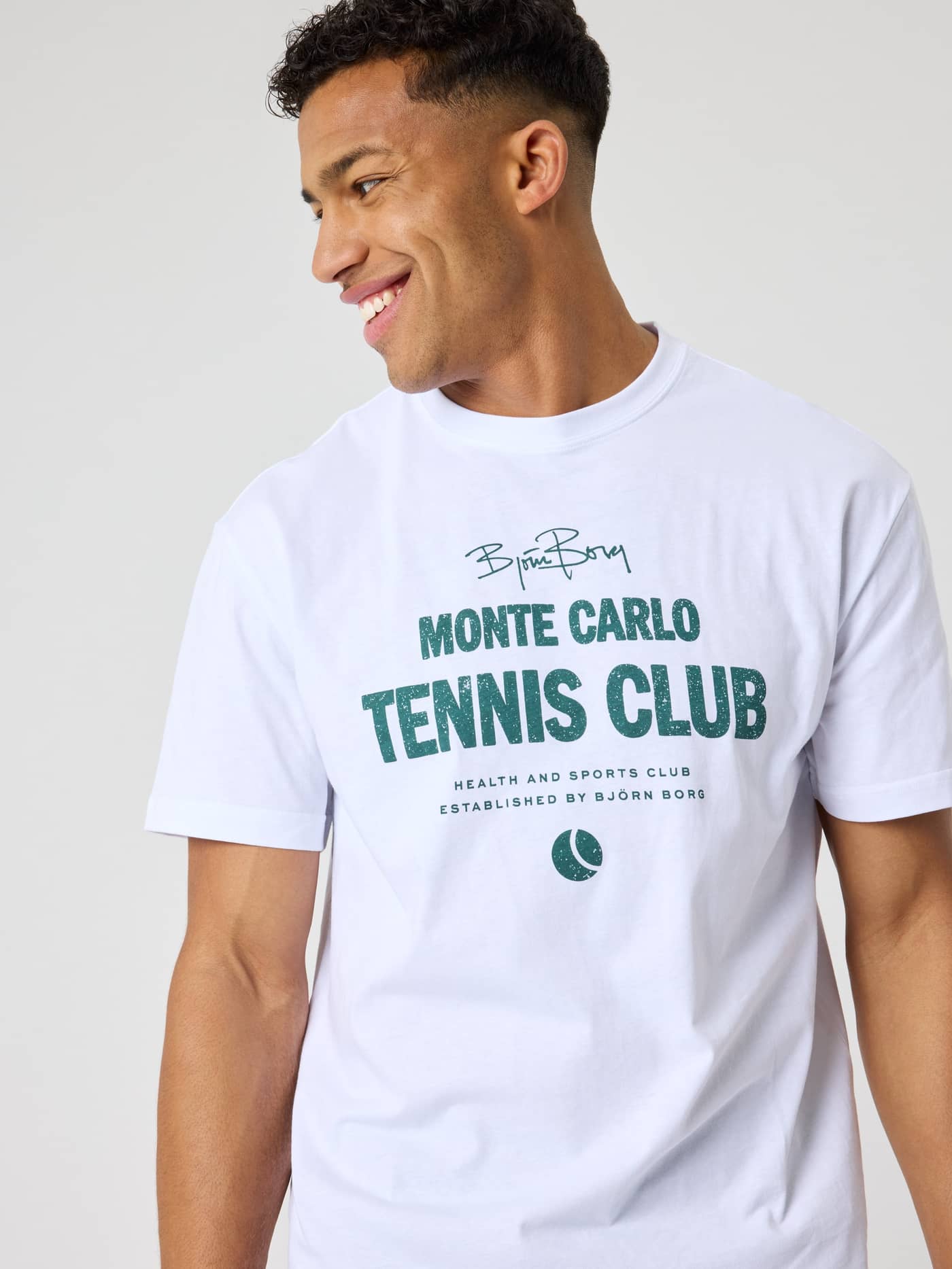 Nahaufnahme eines Mannes im Borg Classic Print T-Shirt aus Baumwolle in Brilliant White (Weiß) mit grüner Tennis-Grafik. - Image 4
