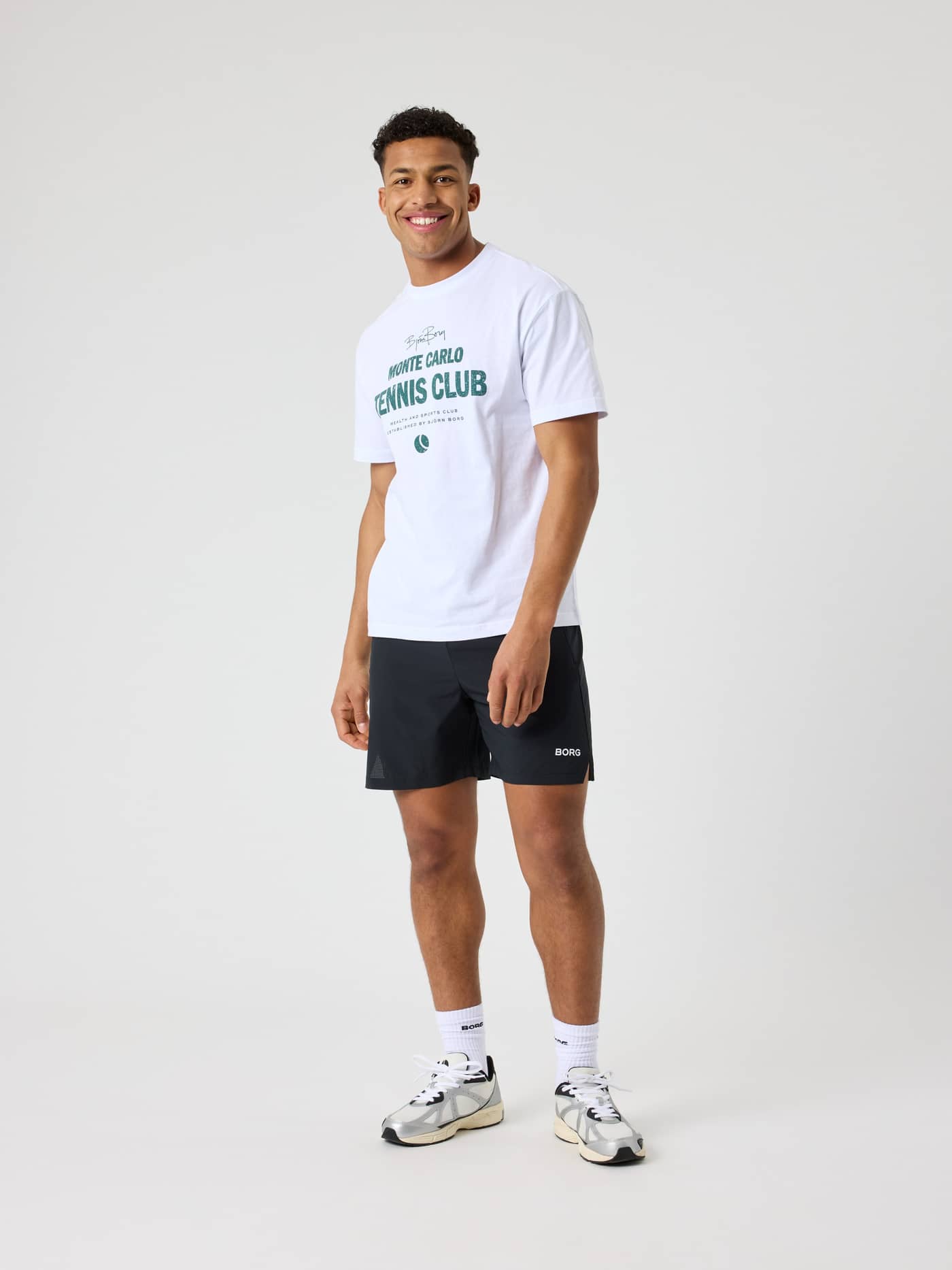 Vorderansicht eines Mannes im Borg Classic Print T-Shirt aus Baumwolle in Brilliant White (Weiß) mit grüner Tennis-Grafik. - Image 3